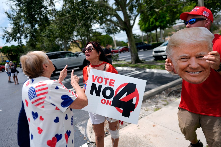 FILE - A supporter of Democratic presidential nominee Vice President Kamala Harris, left, argues about abortion rights with supporters of Republican presidential nominee former President Donald Trump, protesting alongside an event kicking off a national "Reproductive Freedom Bus Tour" by the Harris-Walz campaign, Tuesday, Sept. 3, 2024, in Boynton Beach, Fla. (AP Photo/Rebecca Blackwell,File)