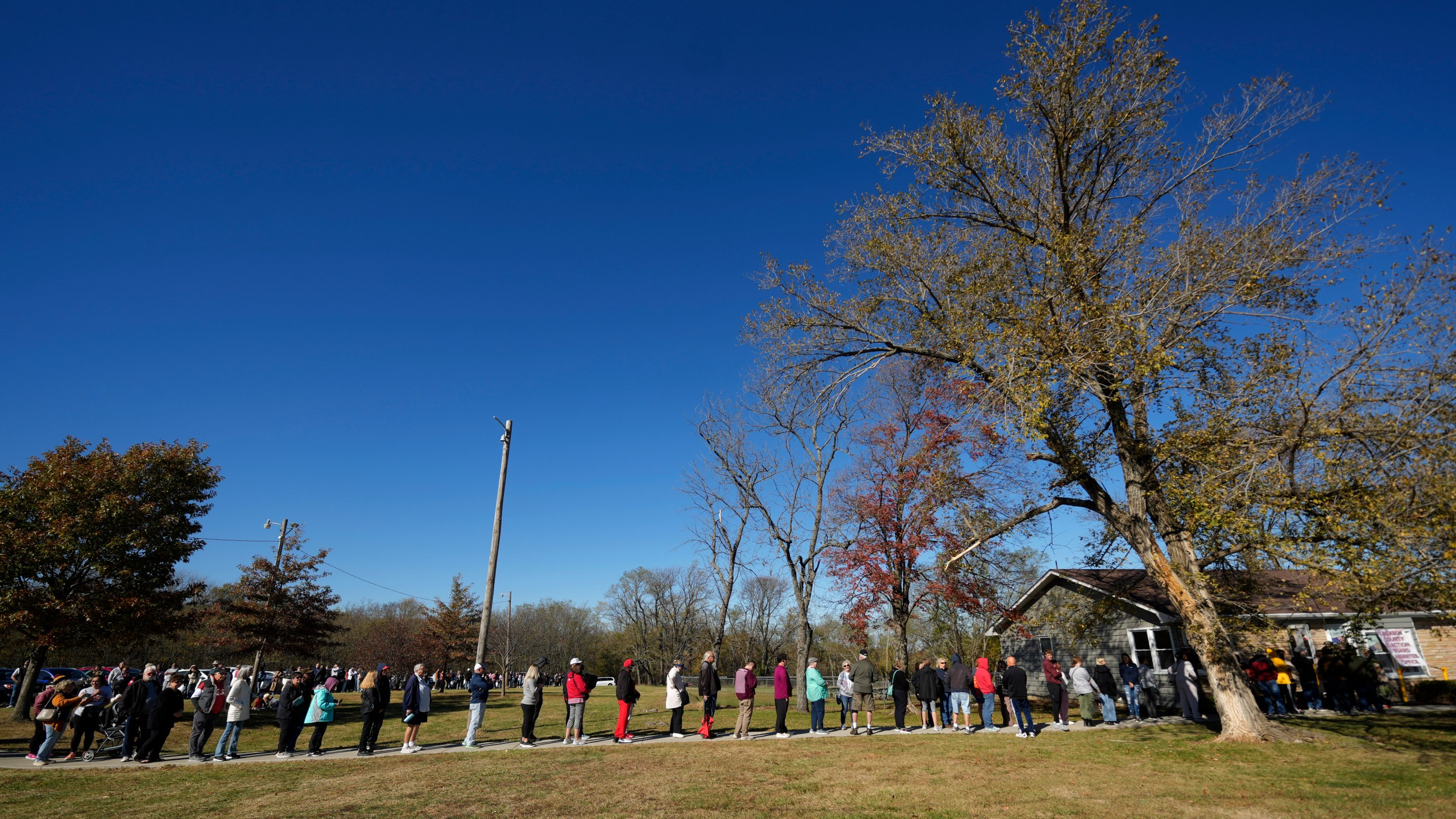 People wait in line to cast their ballots at an early voting location, Thursday, Oct. 31, 2024, in Blue Springs, Mo. (AP Photo/Charlie Riedel)