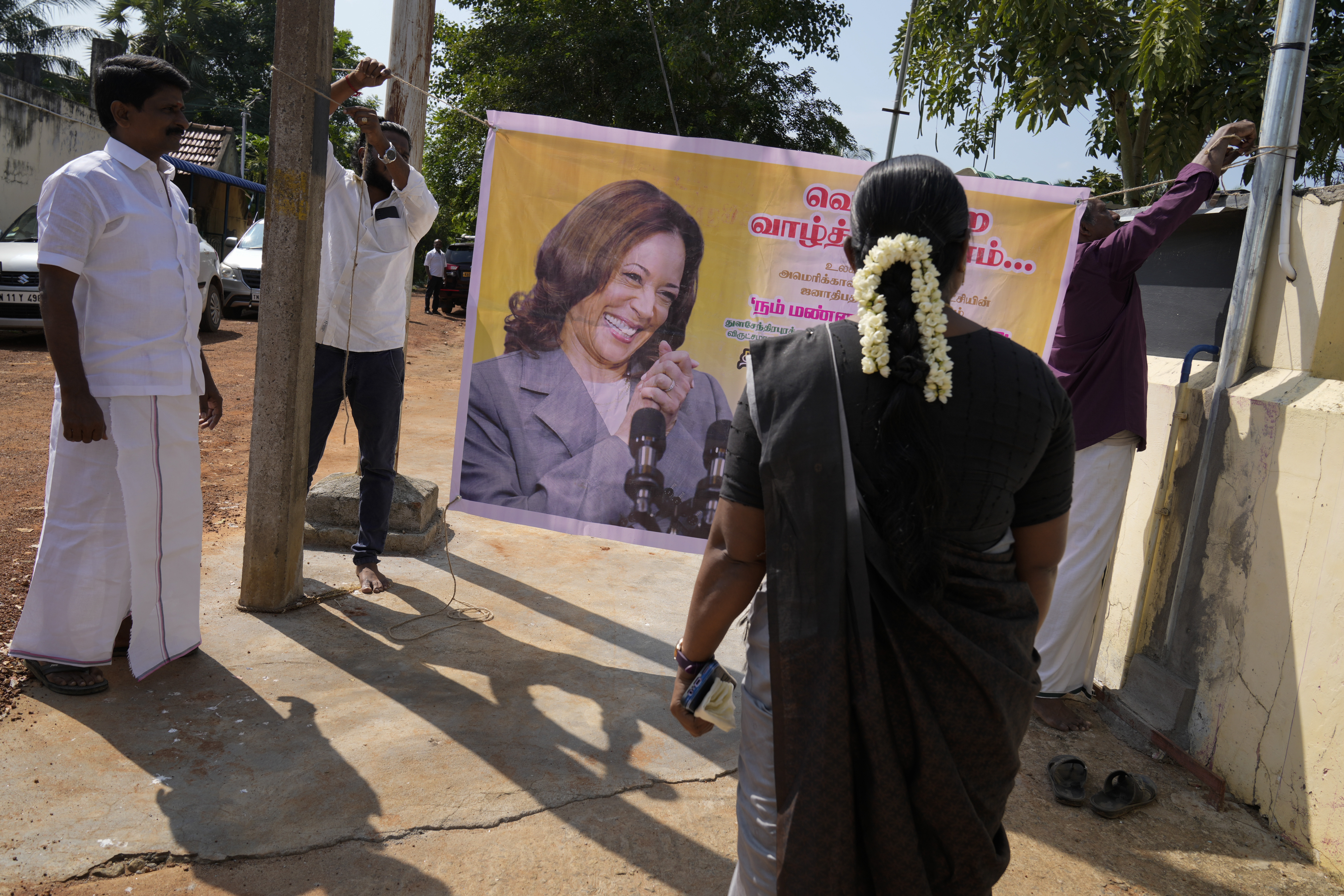 Villagers tie a banner featuring Democratic presidential nominee Vice President Kamala Harris outside a temple in Thulasendrapuram, the ancestral village of Harris, in Tamil Nadu state, India, Tuesday, Nov. 5, 2024. (AP Photo/Aijaz Rahi)