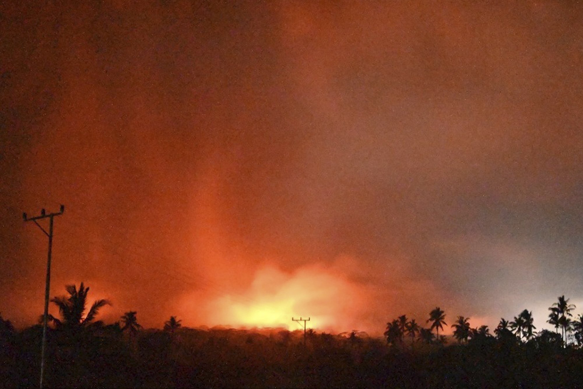 In this photo made available by Indonesia's Center for Volcanology and Geological Disaster Mitigation Agency (PVMBG) of the Ministry of Energy and Mineral Resources, the sky glows from the eruption of Mount Lewotobi Laki-Laki early Monday, Nov. 4, 2024, in East Flores, Indonesia. (PVMBG via AP)