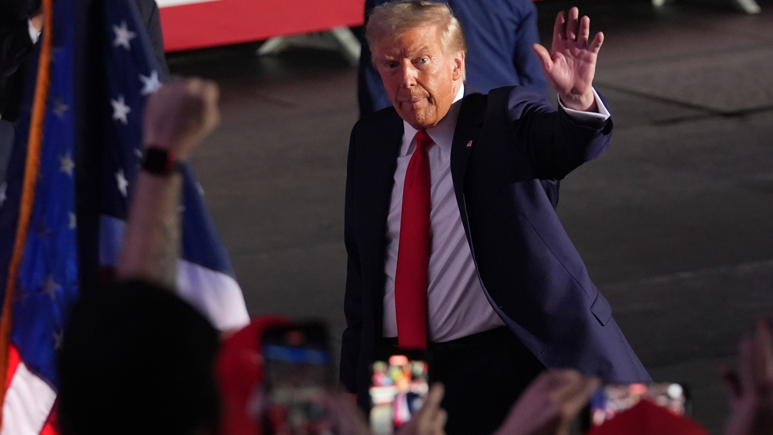 Republican presidential nominee former President Donald Trump waves as he departs a campaign rally at Van Andel Arena, Tuesday, Nov. 5, 2024, in Grand Rapids, Mich. (AP Photo/Paul Sancya)