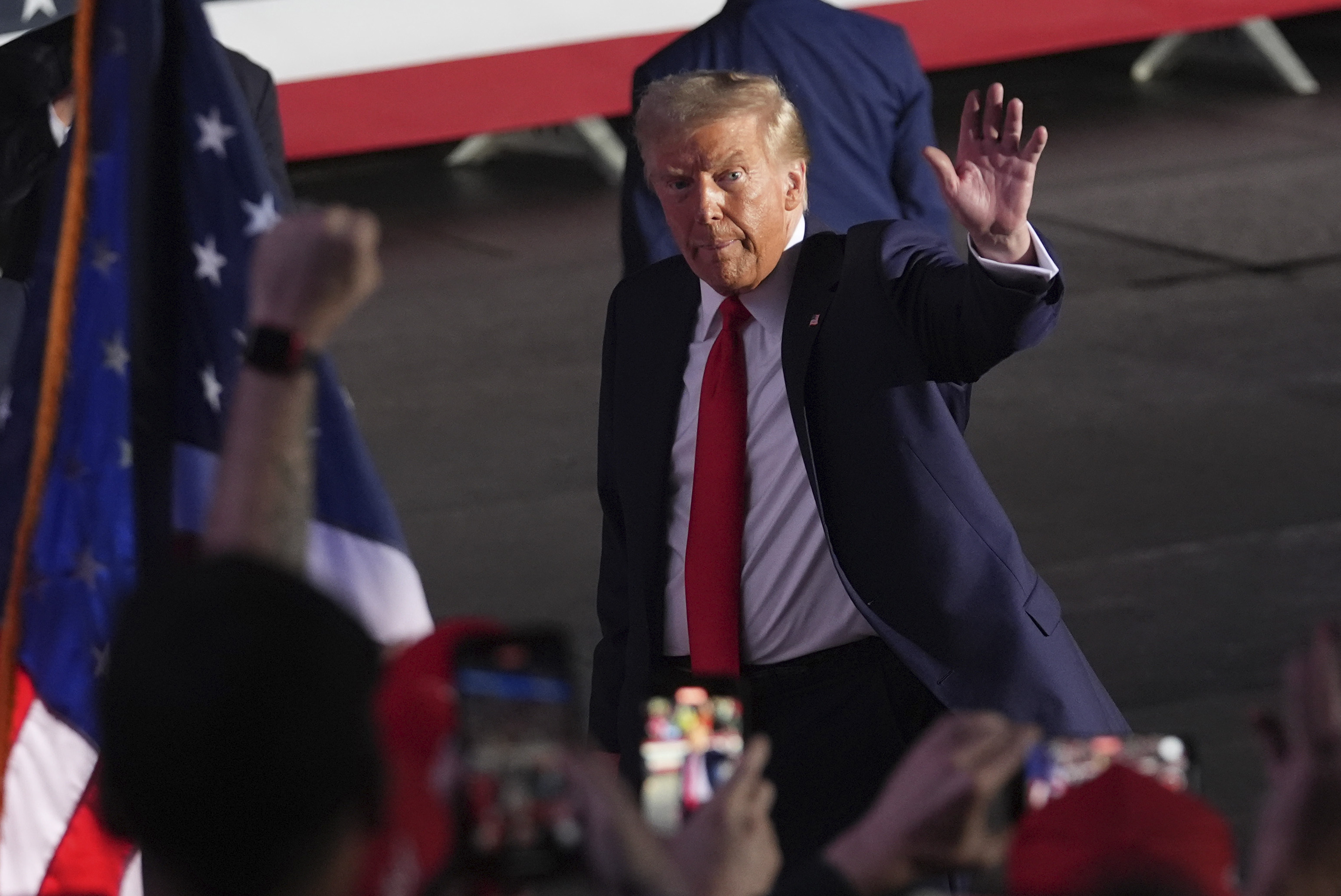 Republican presidential nominee former President Donald Trump waves as he departs a campaign rally at Van Andel Arena, Tuesday, Nov. 5, 2024, in Grand Rapids, Mich. (AP Photo/Paul Sancya)