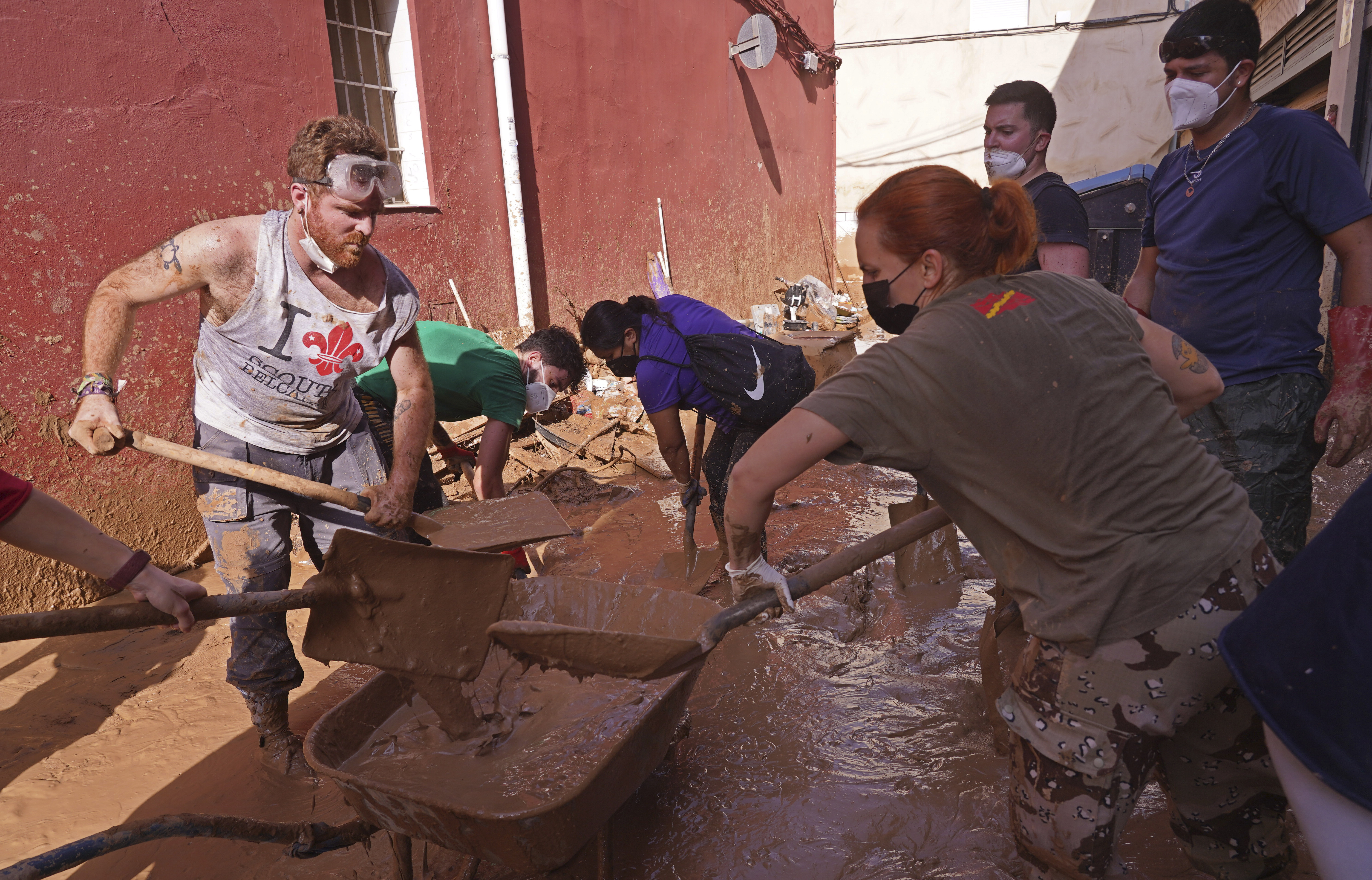 People shovel up mud after floods in Catarroja on the outskirts of Valencia, Spain, Tuesday, Nov. 5, 2024. (AP Photo/Alberto Saiz)