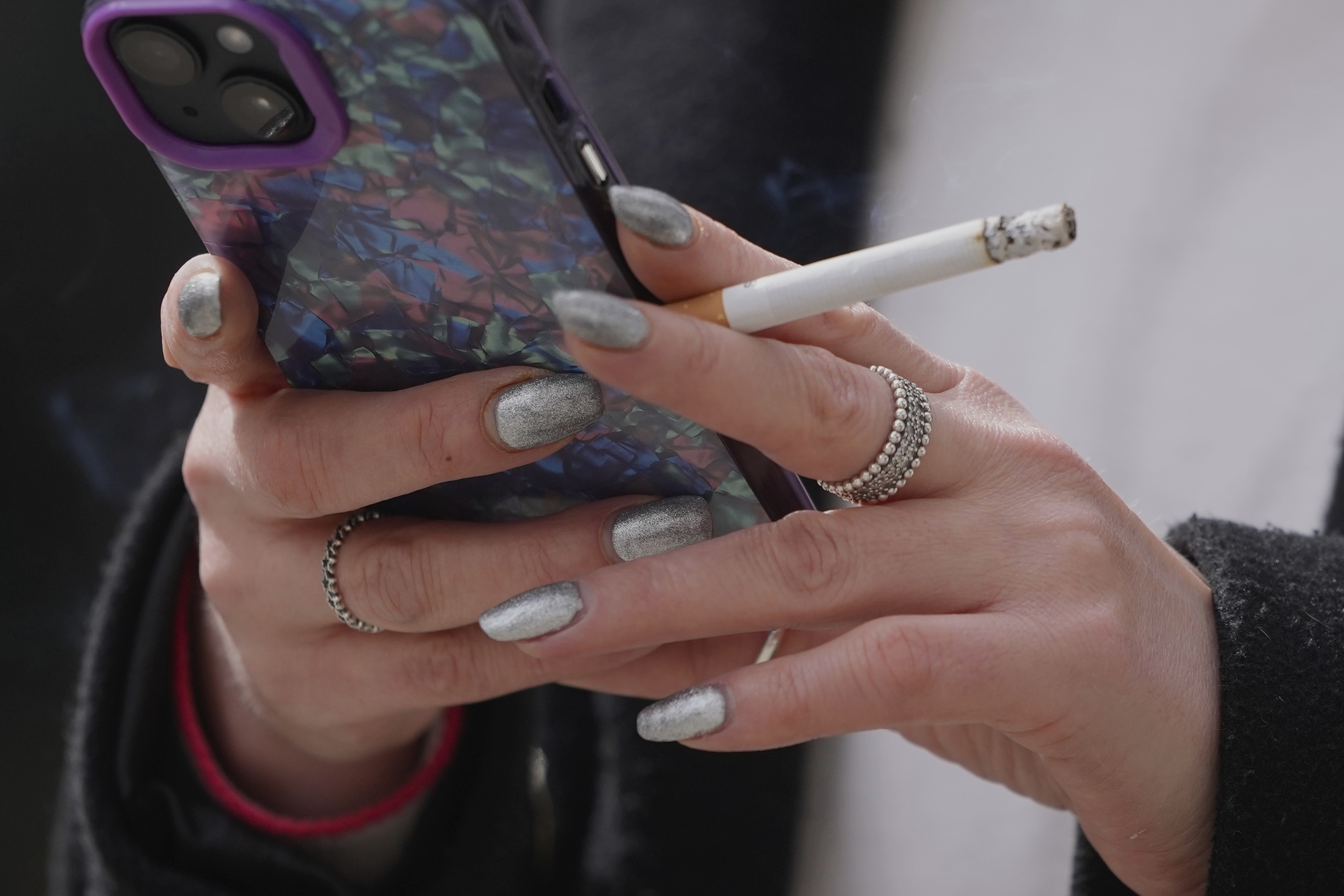 FILE - A woman smokes on a street in London, on April 16, 2024. (AP Photo/Kin Cheung, File)