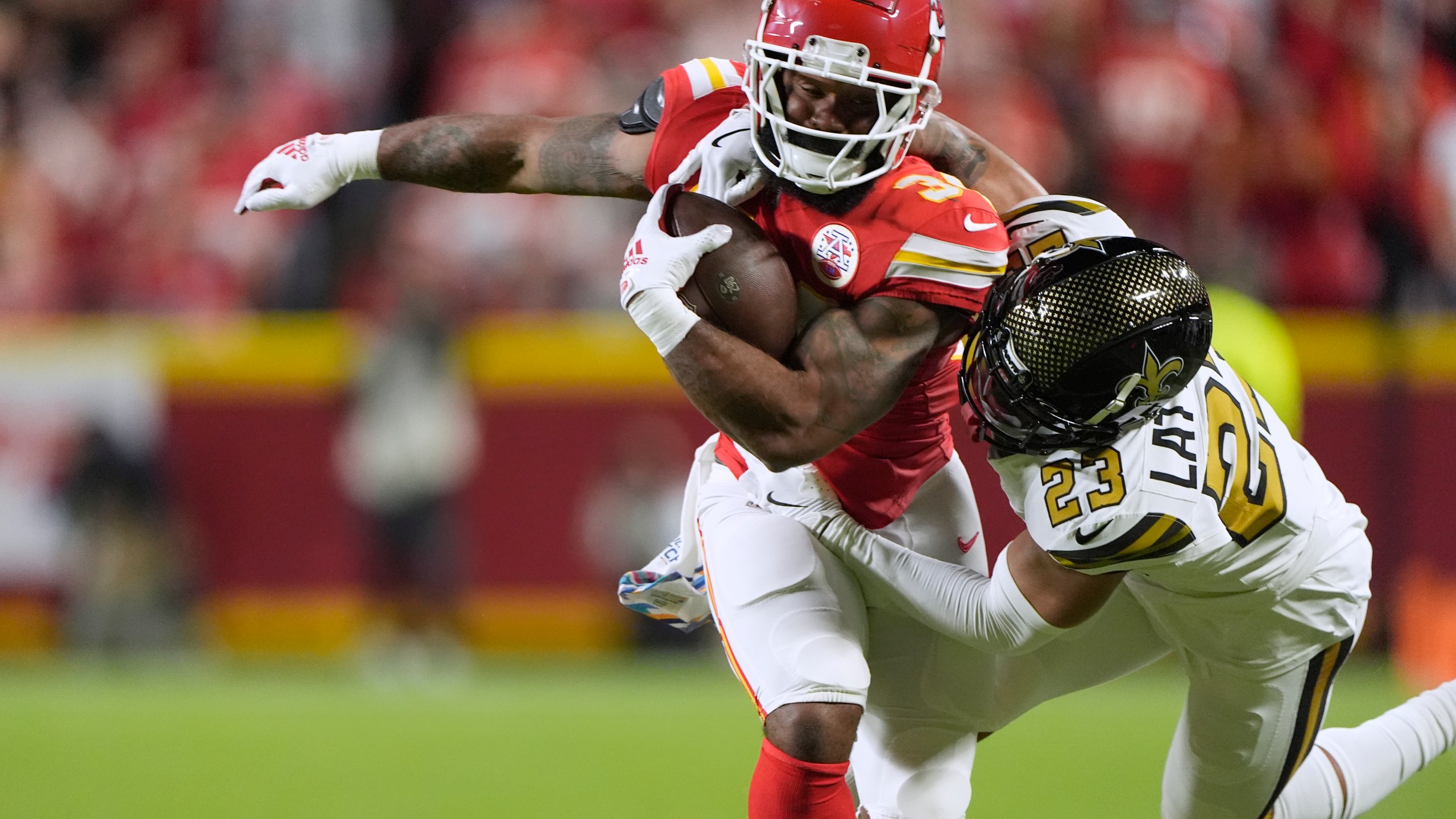 Kansas City Chiefs running back Samaje Perine, left, is stopped by New Orleans Saints cornerback Marshon Lattimore (23) during the first half of an NFL football game Monday, Oct. 7, 2024, in Kansas City, Mo. (AP Photo/Charlie Riedel)