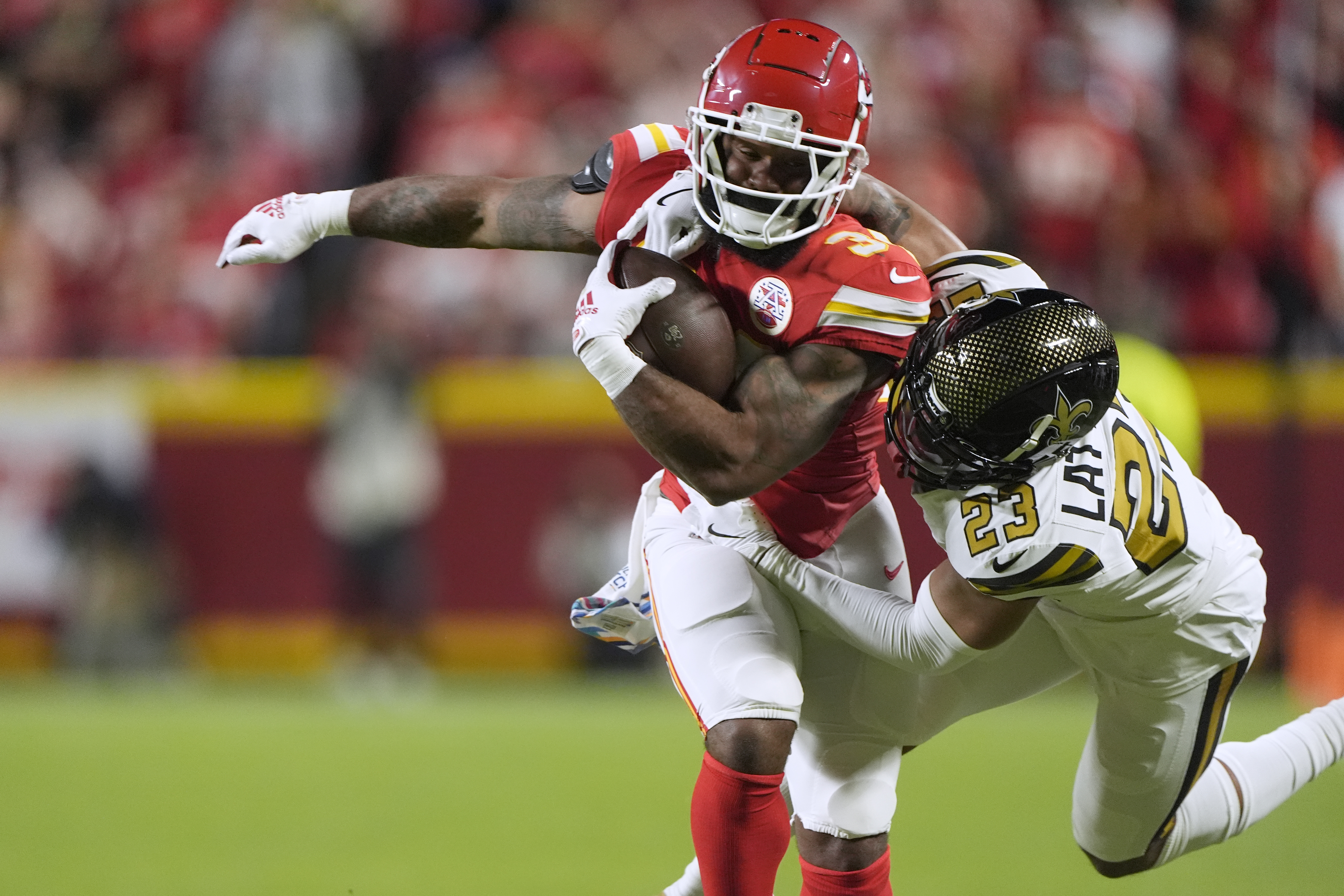 Kansas City Chiefs running back Samaje Perine, left, is stopped by New Orleans Saints cornerback Marshon Lattimore (23) during the first half of an NFL football game Monday, Oct. 7, 2024, in Kansas City, Mo. (AP Photo/Charlie Riedel)