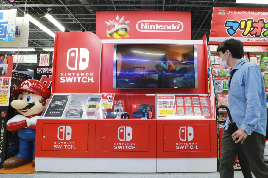 FILE - A man walks by Switch from Nintendo at an electronics retail chain store in Tokyo, on Oct. 13, 2021. (AP Photo/Koji Sasahara, File)