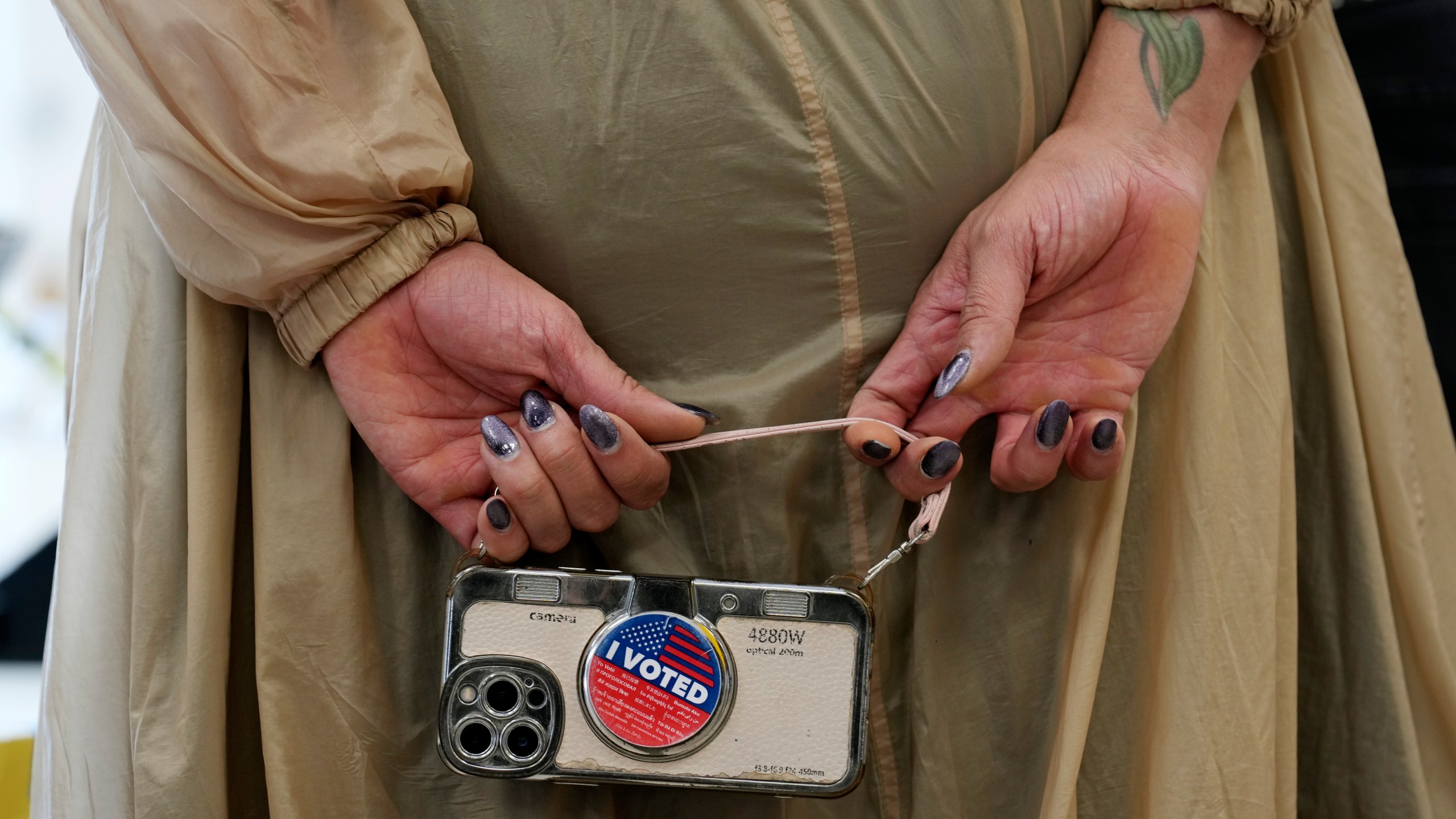 Marsha Molinari of West Hollywood, Calif., holds a cell phone at a polling place at the Connie Norman Transgender Empowerment Center on Election Day, Tuesday, Nov. 5, 2024, in West Hollywood, Calif. (AP Photo/Chris Pizzello)