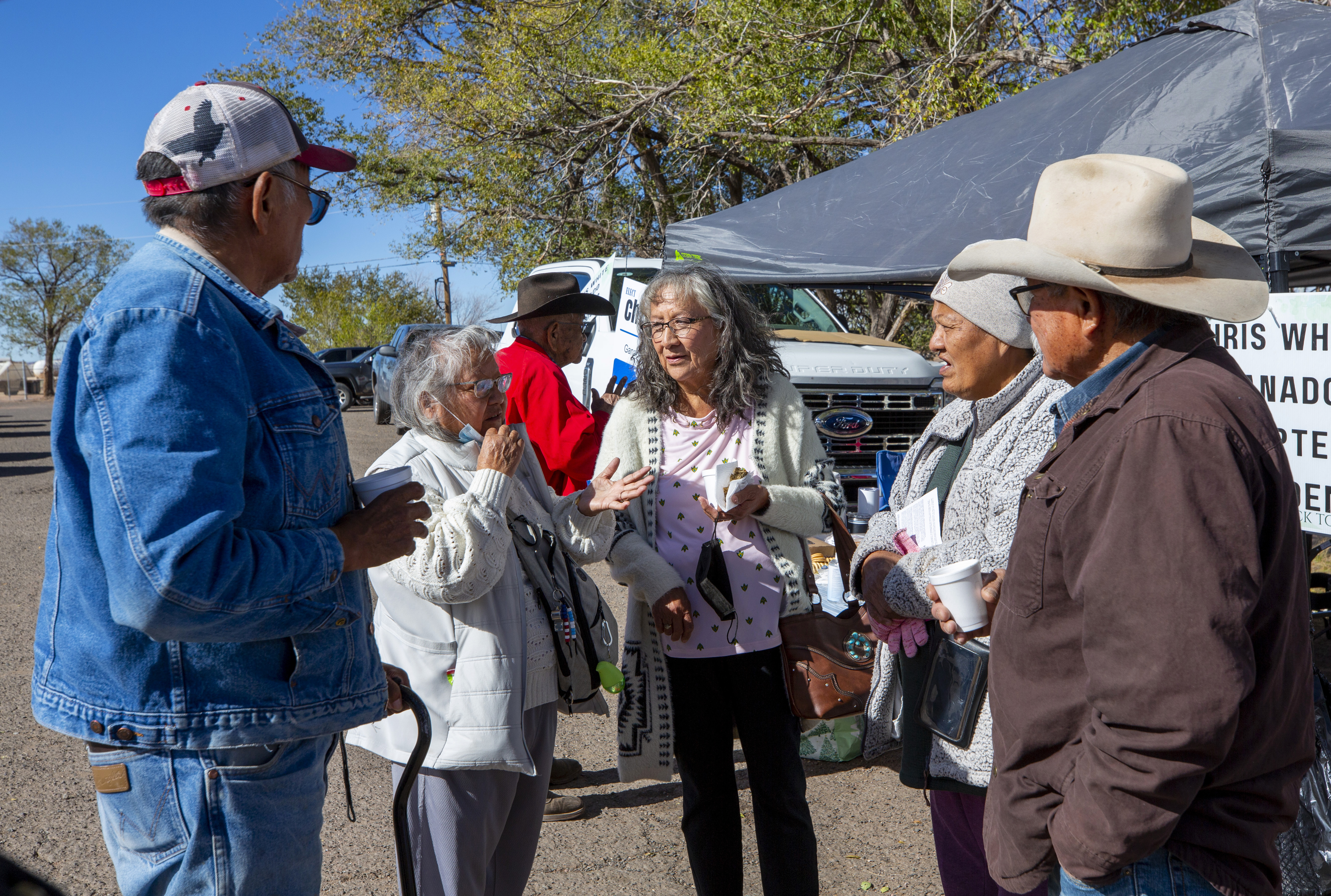 Pauline Larry, second from left, discuss community issues with fellow voters outside a polling station on the Navajo Nation in Ganado, Ariz., on Election Day, Tuesday, Nov. 5, 2024. (AP Photo/Andres Leighton)