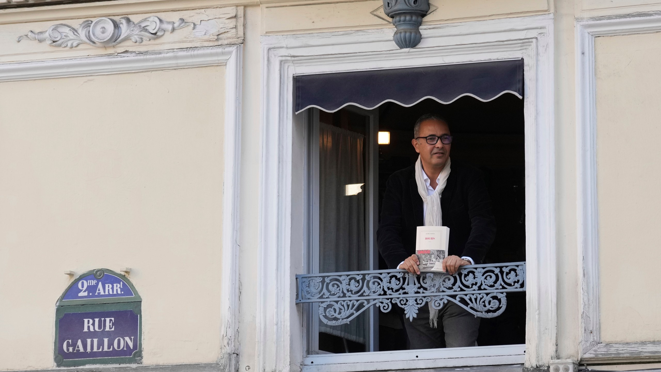 Algerian-French novelist Kamel Daoud holds his book Houris after being awarded with the Goncourt, France's most prestigious literary prize, Monday, Nov. 4, 2024 in Paris. (AP Photo/Aurelien Morissard)