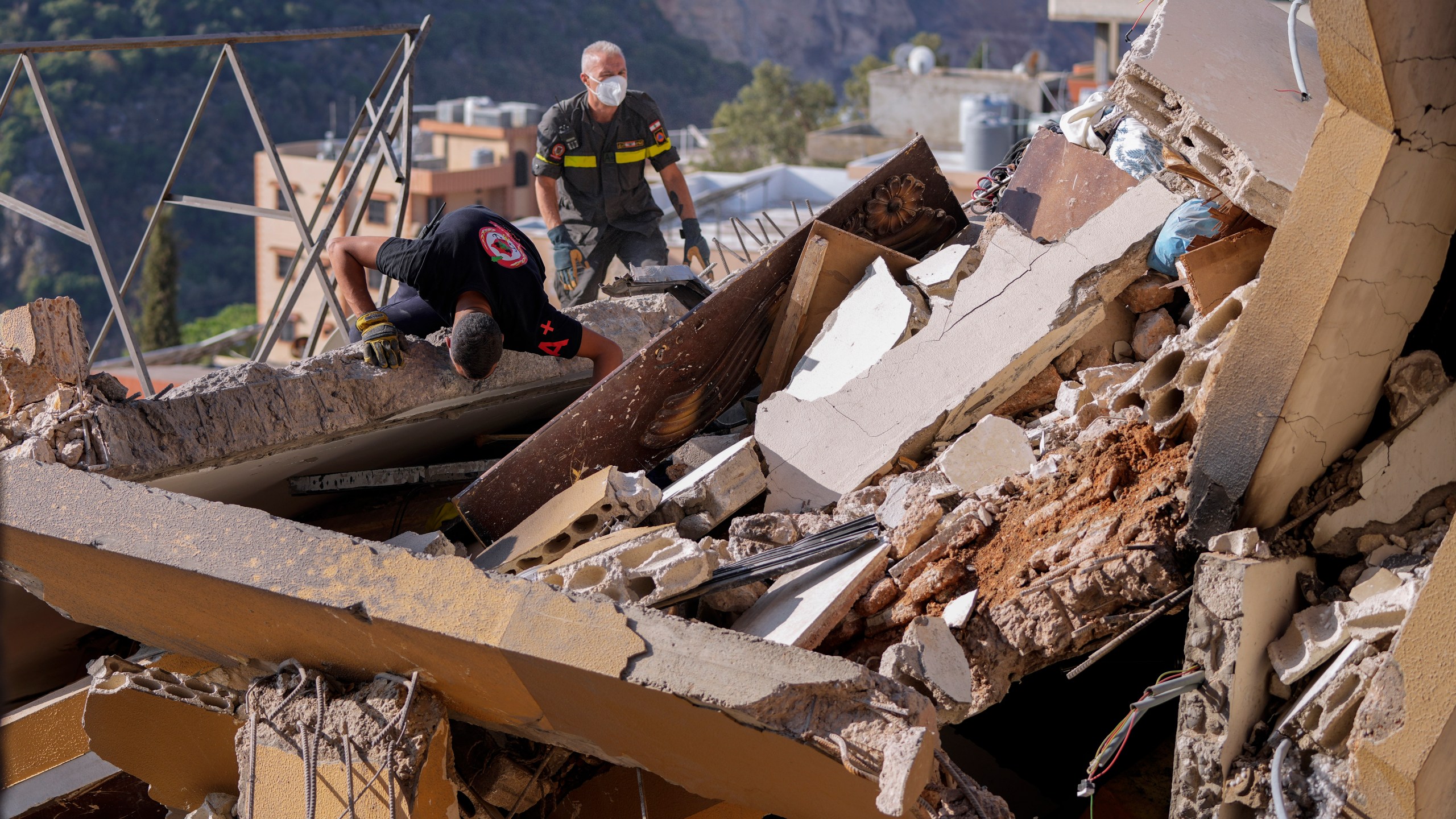 Rescue workers search for victims in the rubble of a destroyed building hit in an Israeli airstrike on Tuesday night, in Barja, Lebanon, Wednesday, Nov. 6, 2024. (AP Photo/Hassan Ammar)