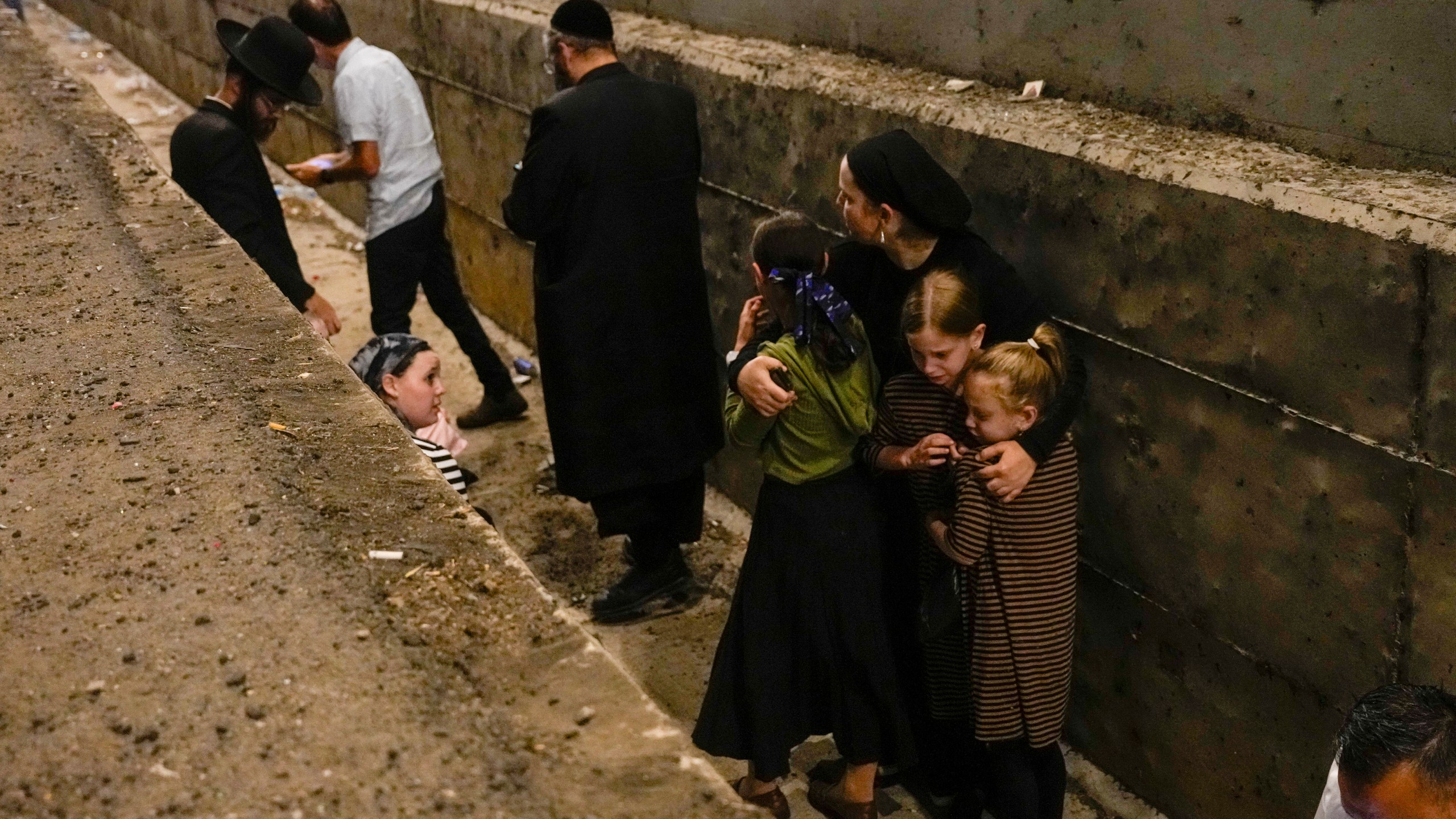 FILE - People take cover on the side of the road as a siren sounds a warning of incoming missiles fired from Iran on a freeway in Shoresh, between Jerusalem and Tel Aviv in Israel Tuesday, Oct. 1, 2024.(AP Photo/Ohad Zwigenberg, File)