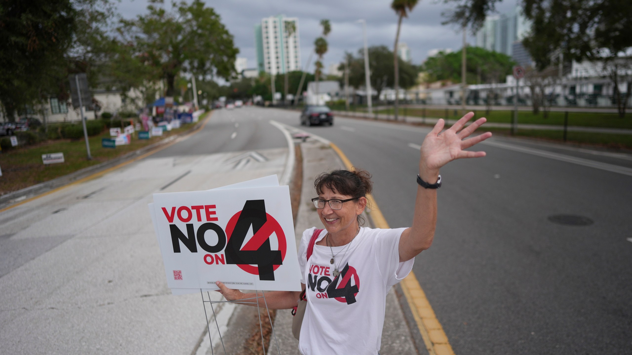 CORRECTS LANGUAGES TO MATCH AP STYLE - Anti-abortion Catholic Sonja Kahkonen waves to passing cars as she holds a "Vote No on 4" sign, urging voters to reject Amendment 4, which would enshrine abortion rights in the state, on Election Day, Tuesday, Nov. 5, 2024, outside a polling place at the Coliseum in St. Petersburg, Fla. (AP Photo/Rebecca Blackwell)