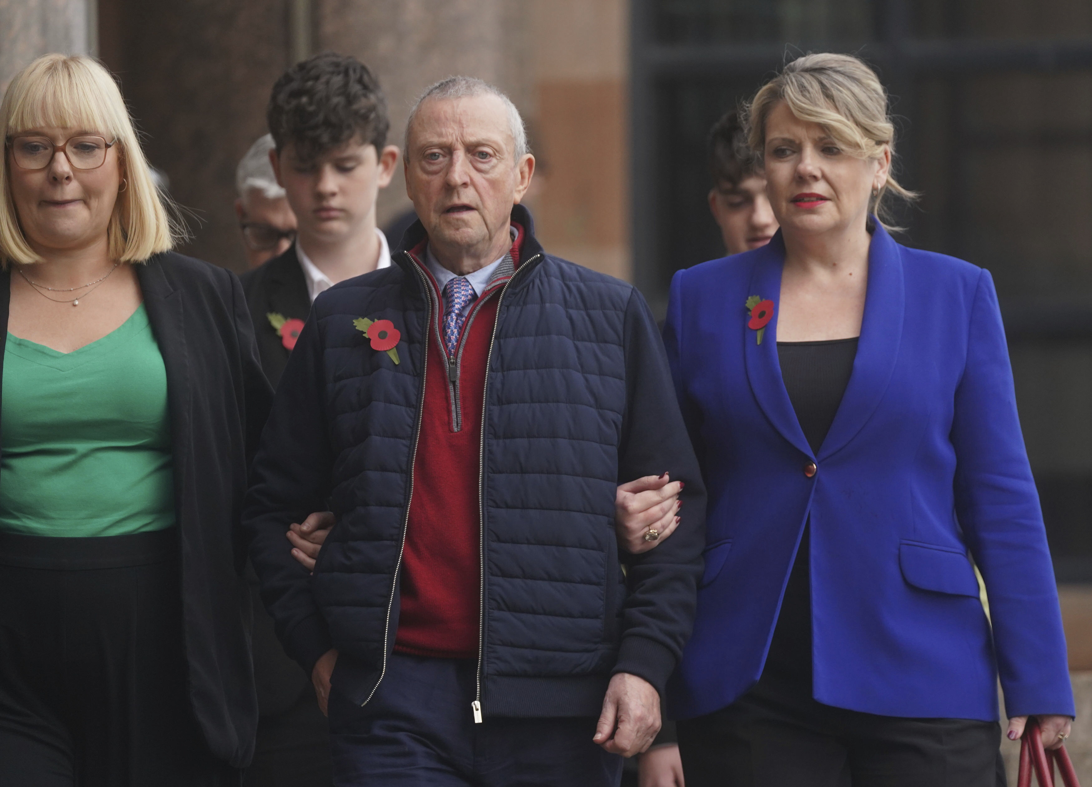 Patrick O'Hara, center, and family members leave Newcastle Crown Court, in Newcastle, England, Wednesday, Nov. 6, 2024 where Dr. Thomas Kwan, was sentenced to 31 years and five months after he attempted to murder Mr O'Hara, who was his mother's partner, with a poisoned fake Covid jab whilst disguised as a nurse. (Owen Humphreys/PA via AP)