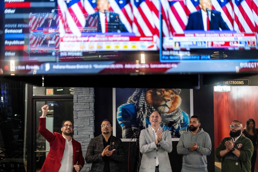 From left to right, Paul Manni, Sam Alasri, Wasel Yousaf, Waseem Makani and Abrahim Tamimi, cheer as former President Donald Trump's speech is broadcast during an Arab Americans for Trump watch party at the Lava Java Cafe, a hookah lounge, in the early hours of Wednesday, Nov. 6, 2024, in Dearborn, Mich. (AP Photo/David Goldman)