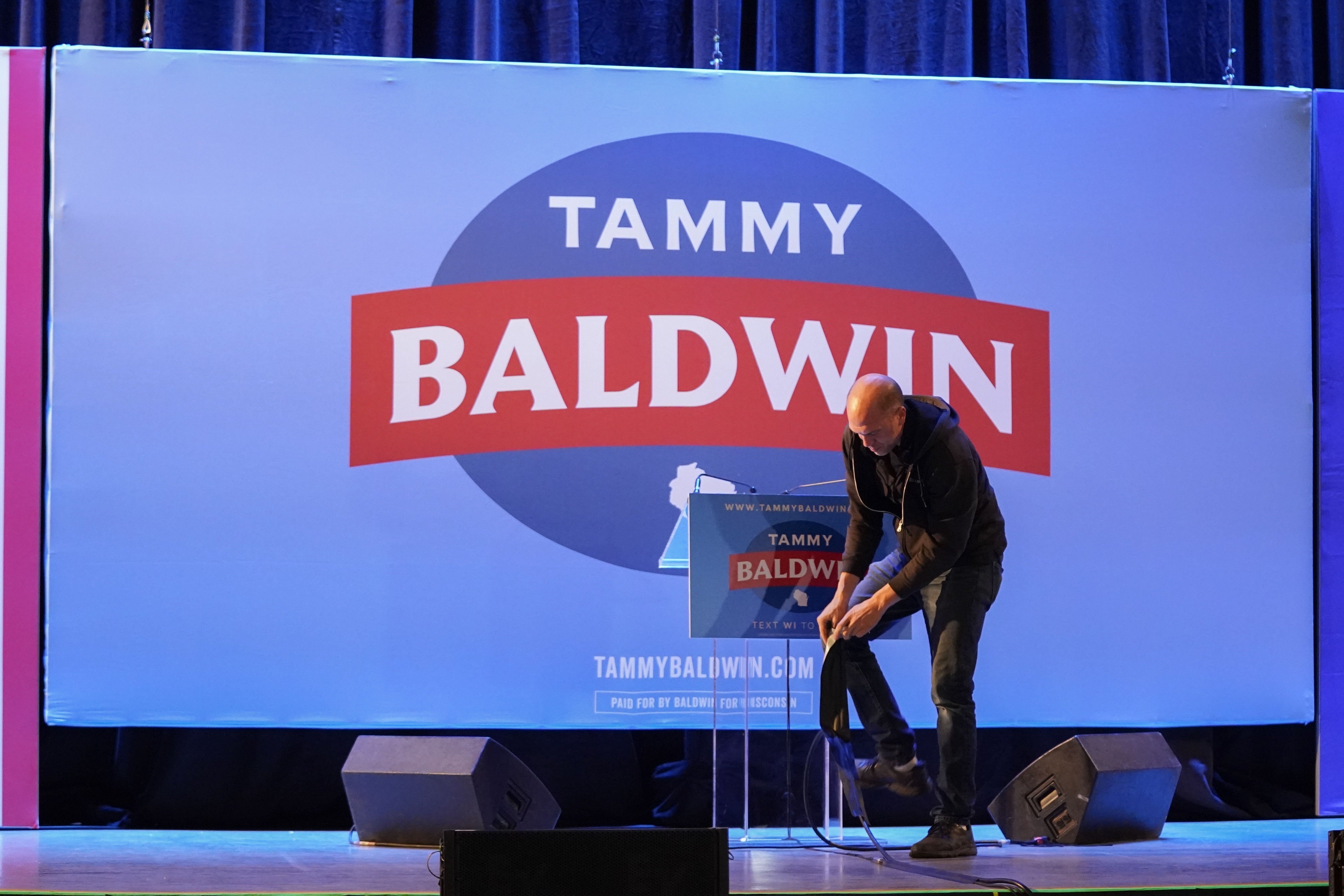 An employee breaks down items on a stage after an election night watch party for Sen. Tammy Baldwin, D-Wis., Wednesday, Nov. 6, 2024, in Madison, Wis. (AP Photo/Kayla Wolf)