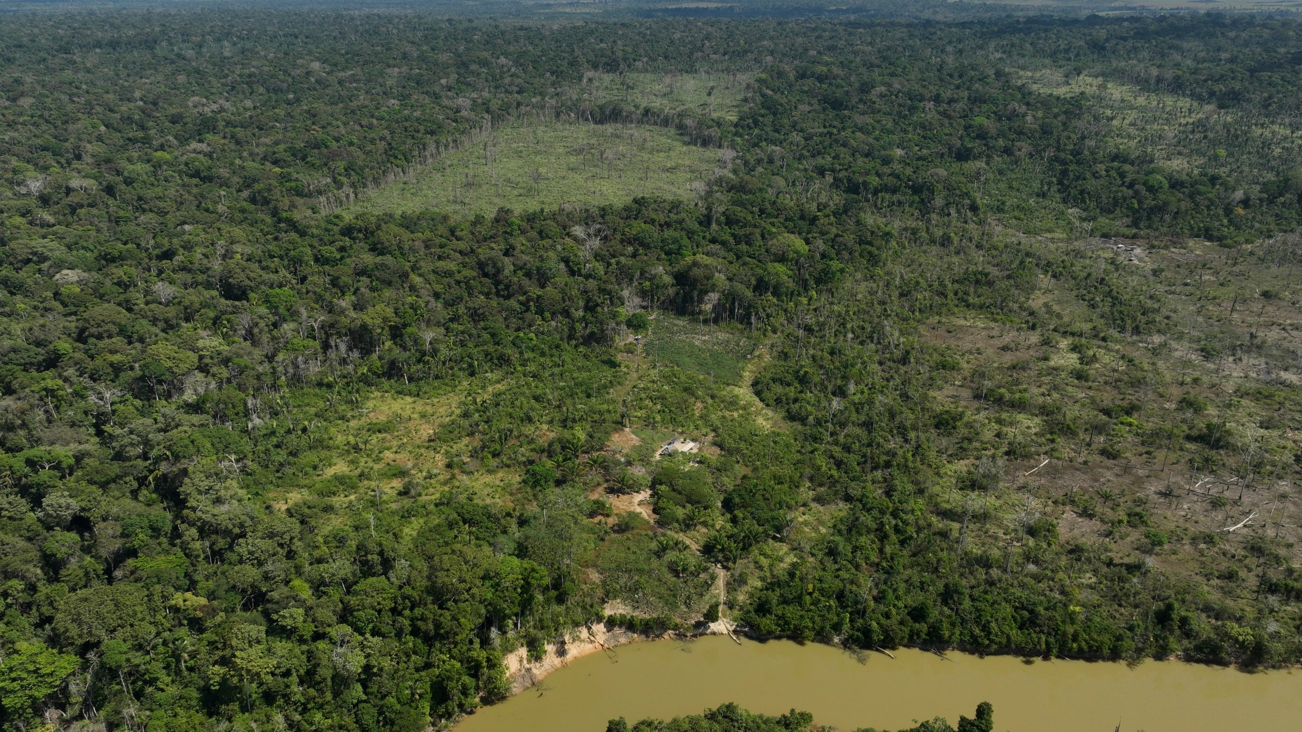 FILE - A river borders an area that has been illegally deforested by land-grabbers and cattle farmers in an extractive reserve in Jaci-Parana, Rondonia state, Brazil, July 11, 2023. (AP Photo/Andre Penner, File)