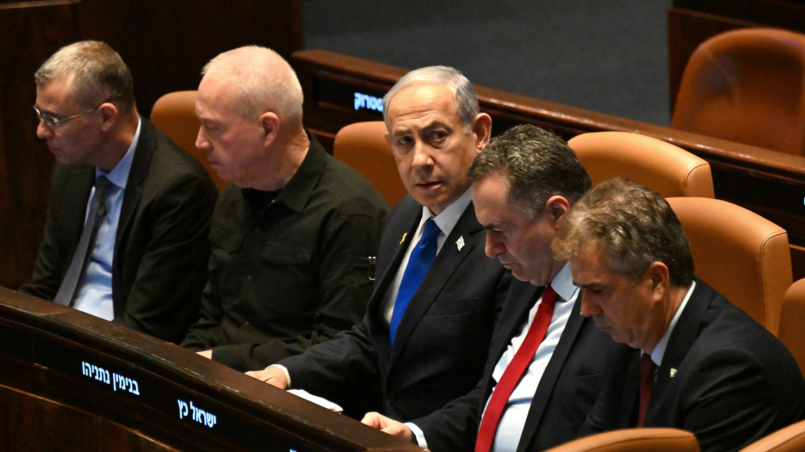 Israeli Prime Minister Benjamin Netanyahu, center, flanked by Defense Minister Yoav Gallant, second from left, attends at the opening of the 25th Knesset session marking the anniversary of the "Iron Swords" war, in Jerusalem, Monday, Oct. 28, 2024. (Debbie Hill/Pool Photo via AP)