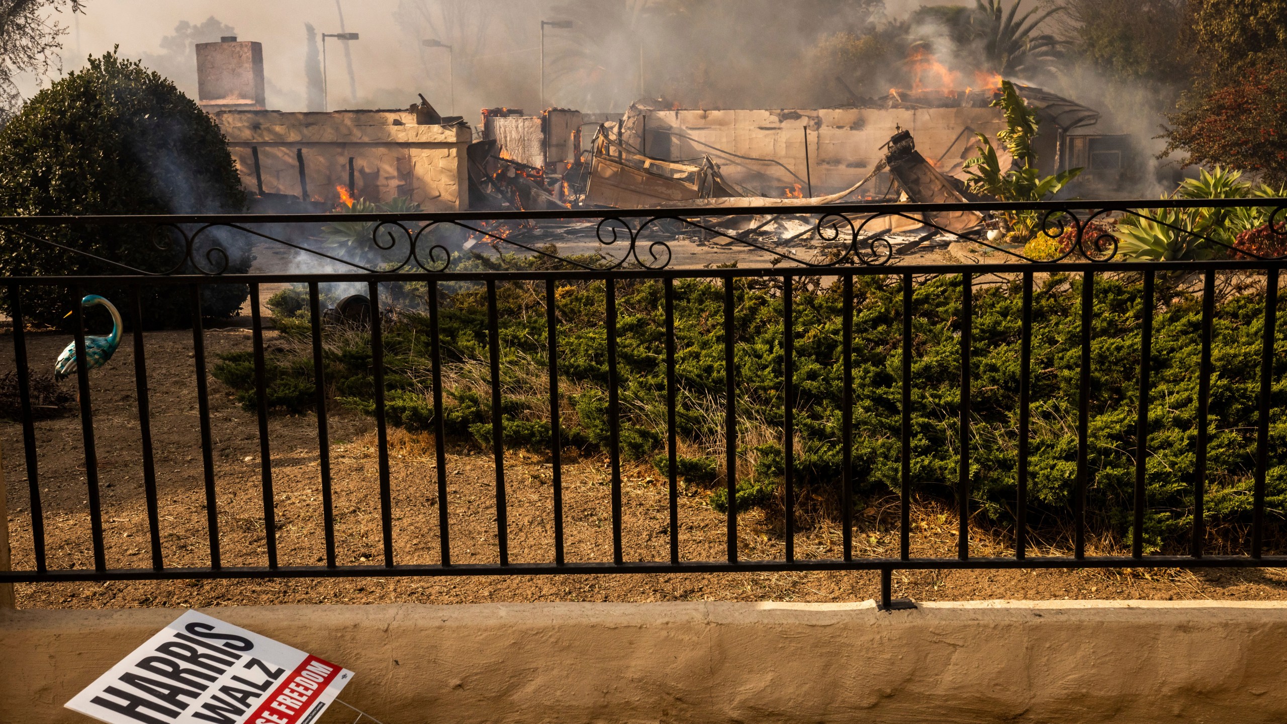 A political sign sits in front of a destroyed home in the Mountain fire, Wednesday, Nov. 6, 2024, near Camarillo, Calif. (AP Photo/Ethan Swope)