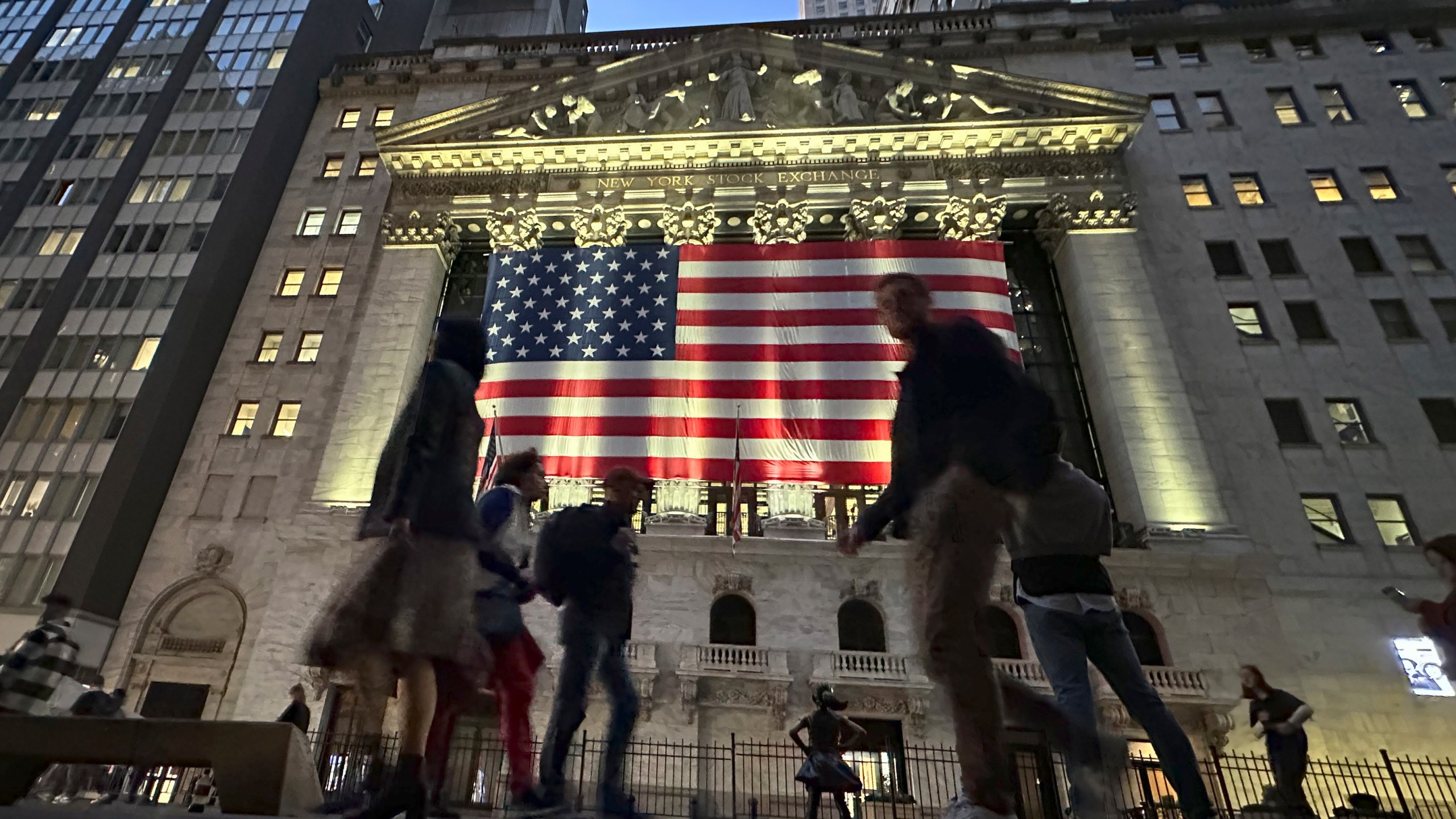 People pass the New York Stock Exchange in New York's Financial District on Tuesday, Nov. 5, 2024. (AP Photo/Peter Morgan)