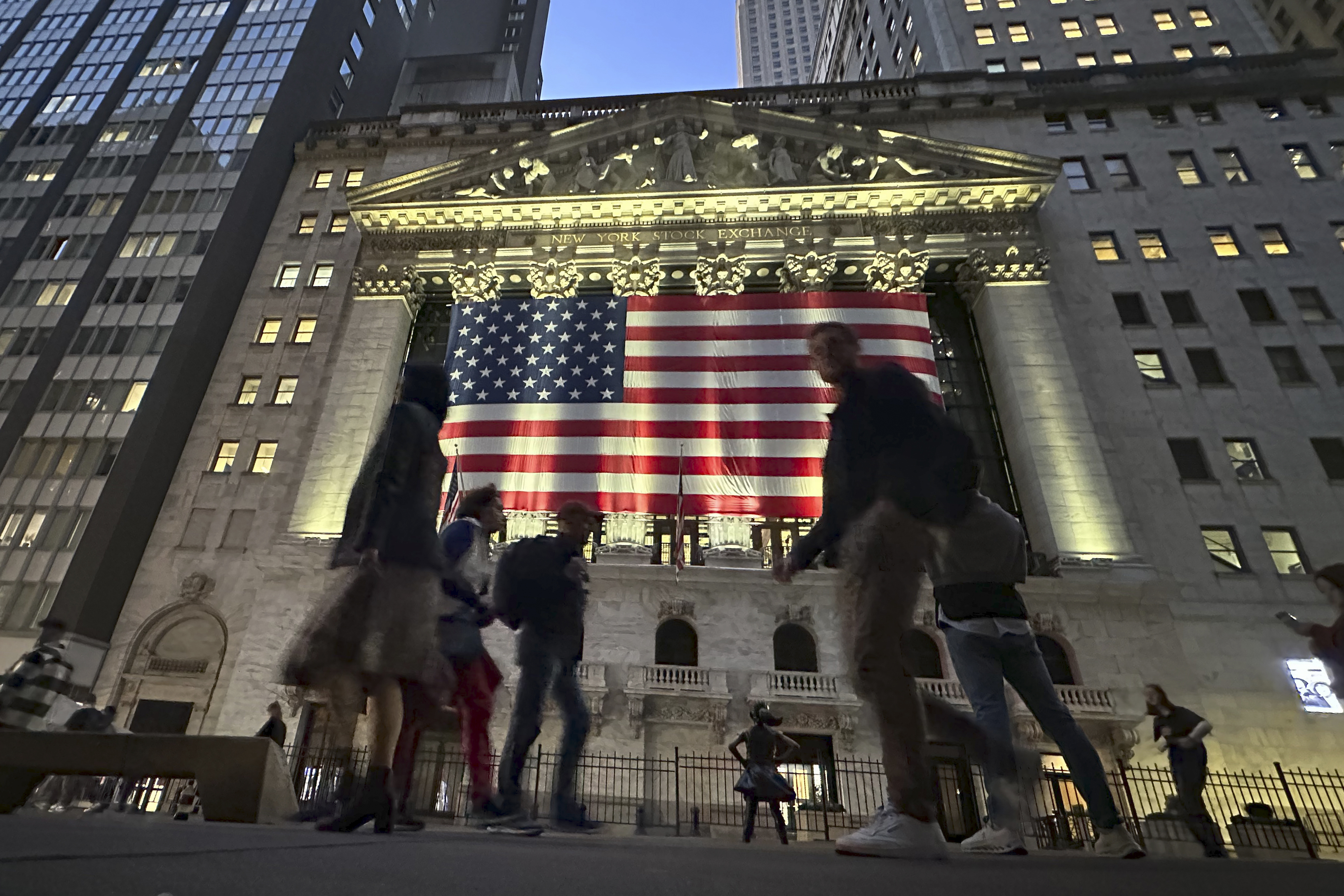 People pass the New York Stock Exchange in New York's Financial District on Tuesday, Nov. 5, 2024. (AP Photo/Peter Morgan)