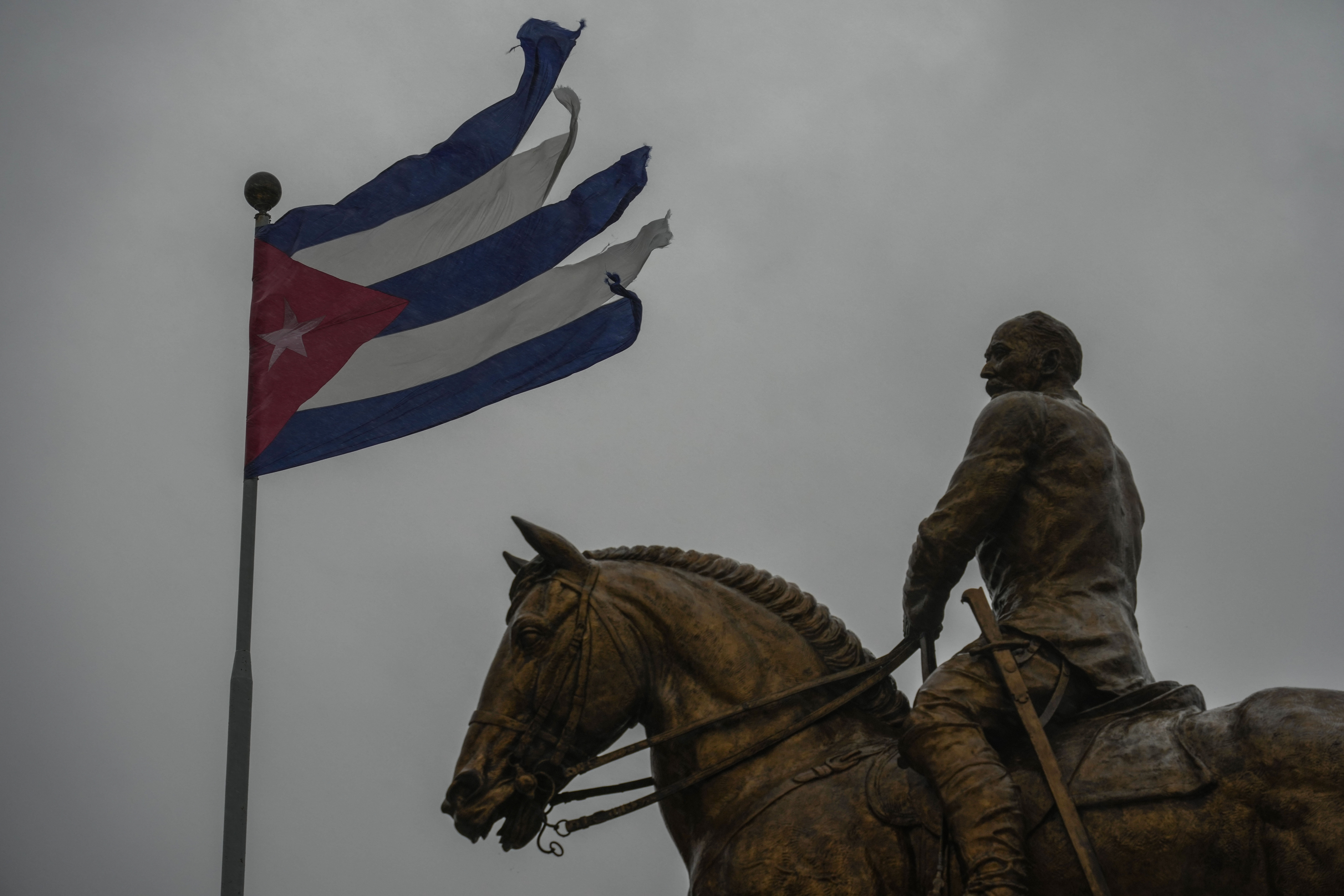 A Cuban flag shredded by the winds of Hurricane Rafael flies above the statue of General Calixto Garcia in Havana, Cuba, Wednesday, Nov. 6, 2024. (AP Photo/Ramon Espinosa)