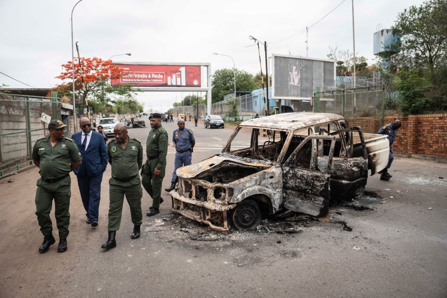 Border officials inspect a burnt-out Mozambican border patrol vehicle at the border crossing in Lebombo, South Africa, Thursday, Nov. 7, 2024. South Africa closed its border with Mozambique shortly after opening it on Thursday as post-election violence in the neighboring country escalated. (AP Photo)