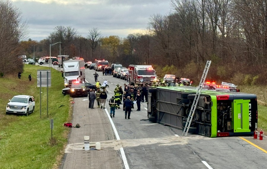 First responders investigate the scene where a tour bus rolled over on westbound Interstate 490 critically injuring one and sending all 28 passengers to area hospitals, Thursday, Nov. 7, 2024, in Chili, N.Y. (Monroe County Sheriff's Office via AP)