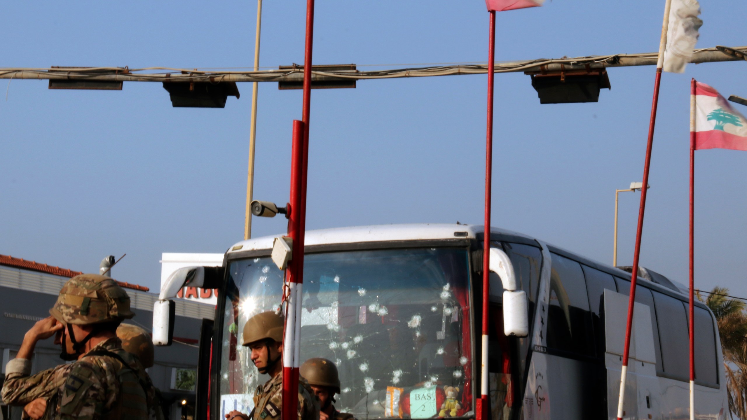 In this handout photo, Lebanese army soldiers stand guard next to a damaged bus of the Malaysian U.N. peacekeepers at the site of an Israeli strike hit a car, in the southern port city of Sidon, Lebanon, Thursday, Nov. 7, 2024. (AP Photo)