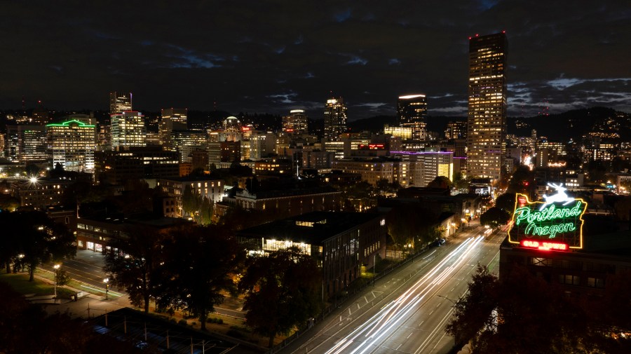 FILE - In this image taken with a slow shutter speed, vehicles drive onto the Burnside Bridge as the White Stag sign is lit up on Tuesday, Oct. 29, 2024, in Portland, Ore. (AP Photo/Jenny Kane, File)