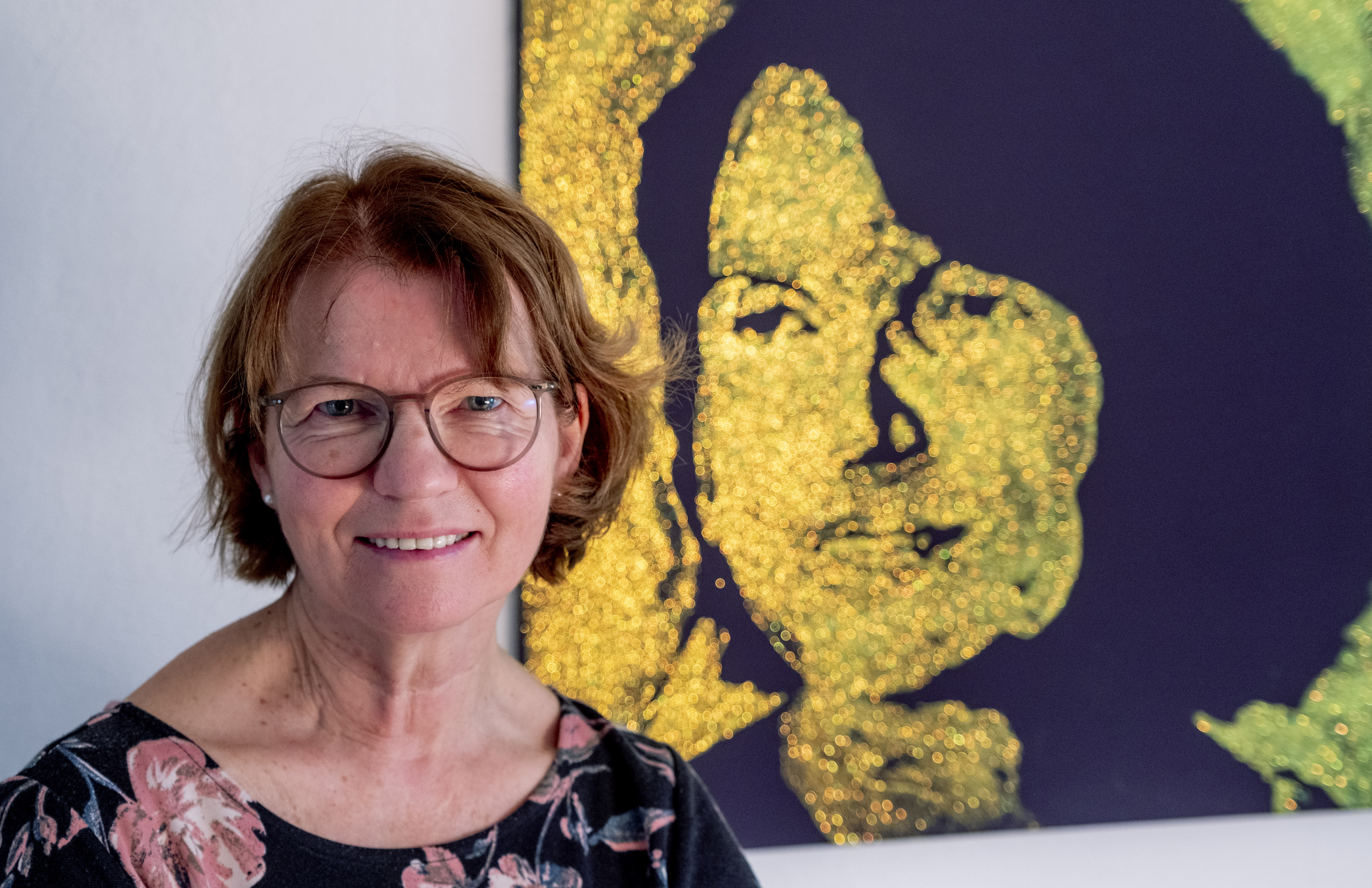 Claudia Huth poses next to a painting showing herself and painted by her son in her house in Egelsbach, Germany, Thursday, Oct. 31, 2024. (AP Photo/Michael Probst)