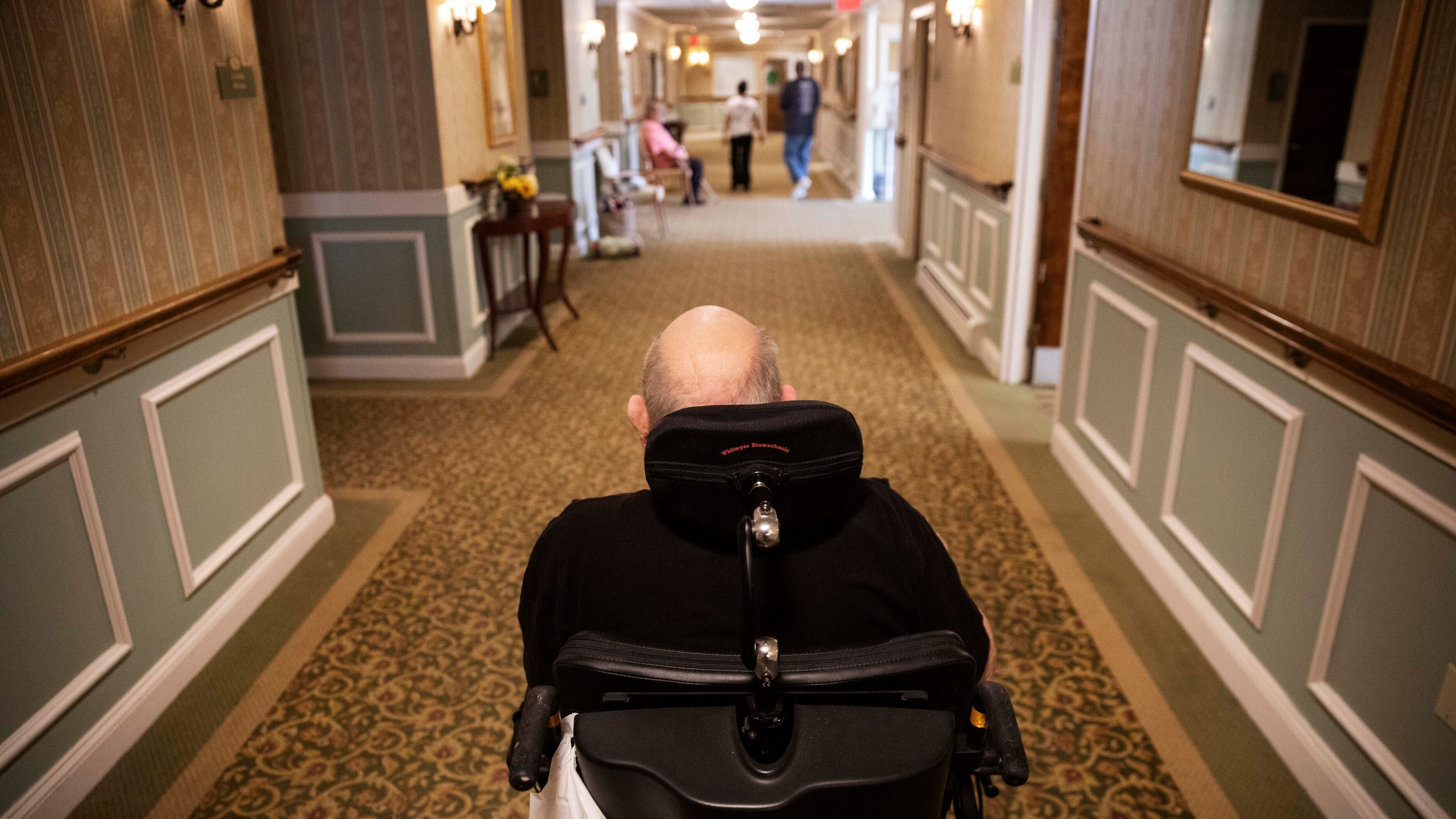 FILE - A resident makes his way to the dining room for lunch at a nursing home in Rockland, Mass., on March 6, 2020. (AP Photo/David Goldman, File)