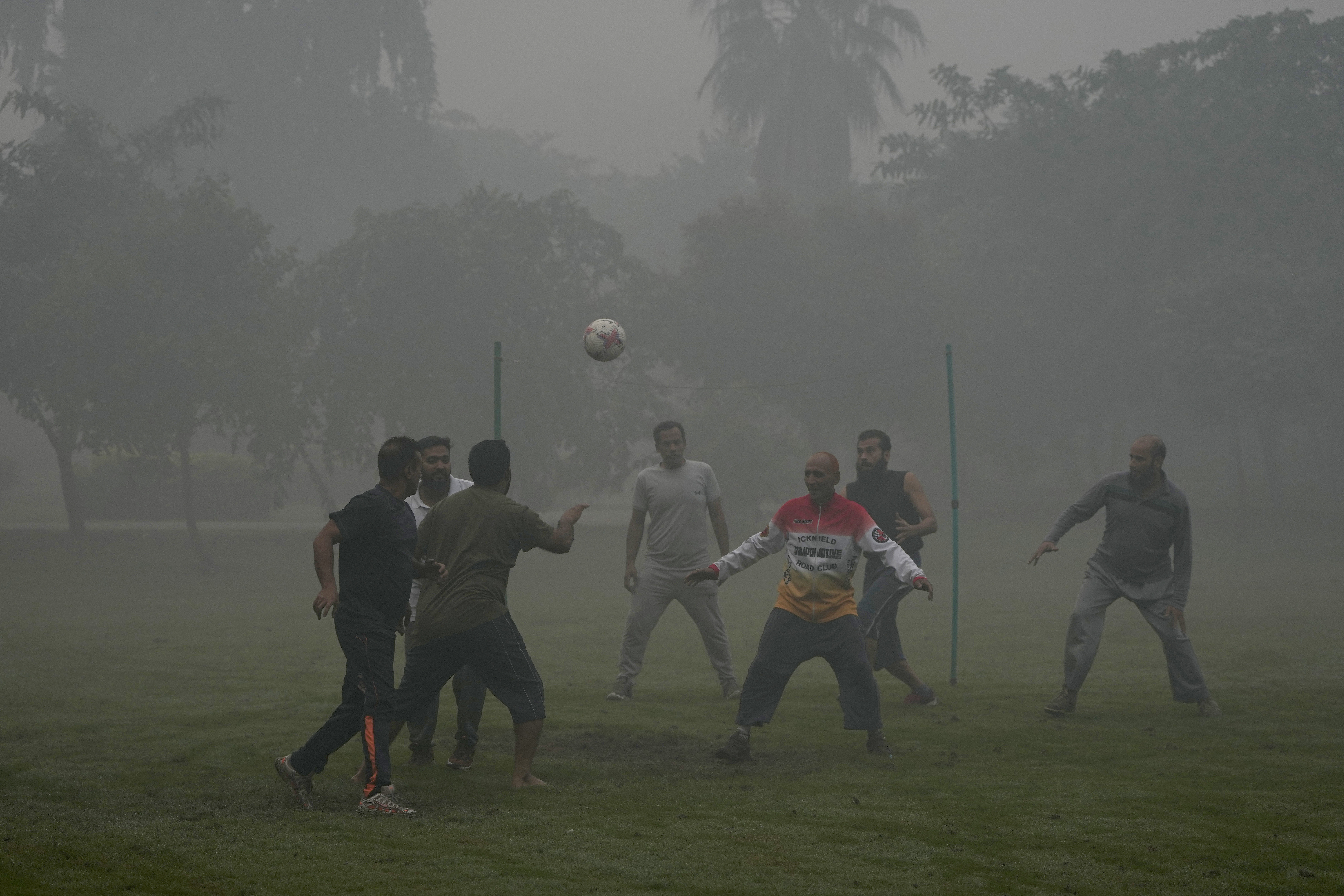 People play with soccer ball in a park in the morning as smog envelops the area of Lahore, Pakistan, Friday, Nov. 8, 2024. (AP Photo/K.M. Chaudary)