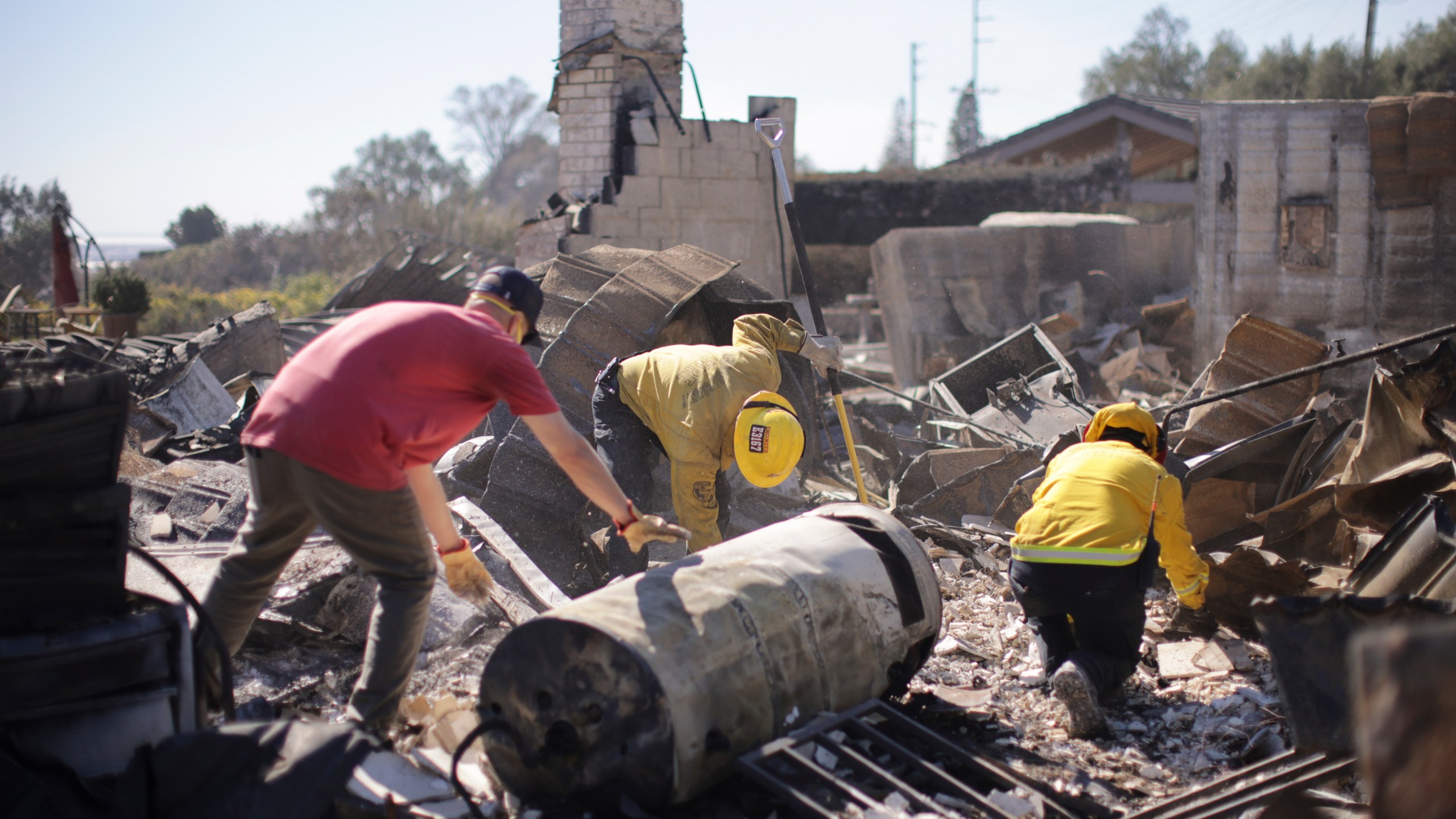 Todd Howard, left, sifts through the remains of his parents' fire-ravaged property with the help of firefighters after the Mountain Fire swept through, Thursday, Nov. 7, 2024, in Camarillo, Calif. (AP Photo/Ethan Swope)