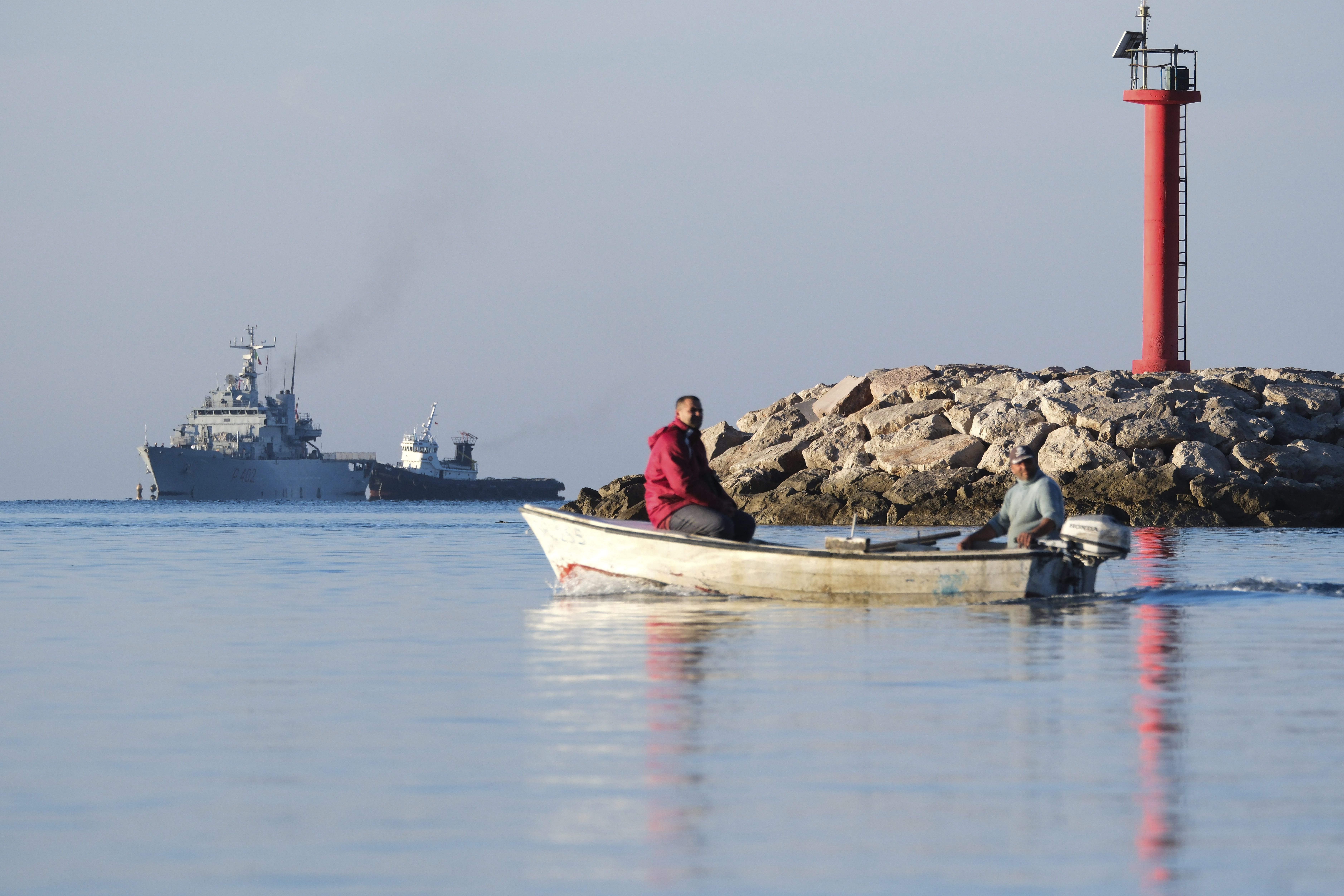 The Italian navy ship Libra, left, approaches the port of Shengjin, northwestern Albania, Friday, Nov. 8, 2024, with the second group of eight migrants intercepted in international waters to be processed there in a reception facility despite the failure with the first group in October. (AP Photo/Vlasov Sulaj)