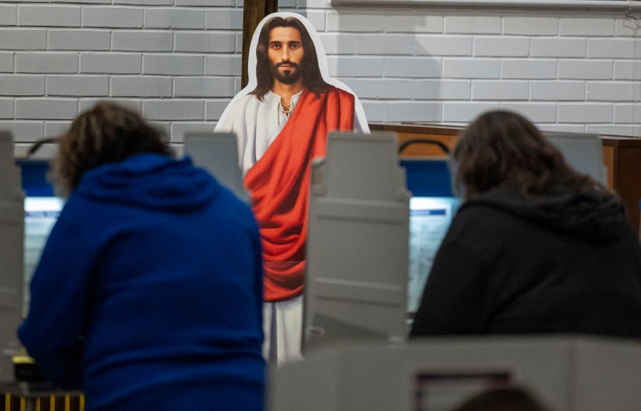 A cutout of Jesus watches over voters at the voting station at Redeemer Lutheran Church on Election Day, Tuesday, Nov. 5, 2024, in Lincoln, Neb. (Kenneth Ferriera/Lincoln Journal Star via AP)