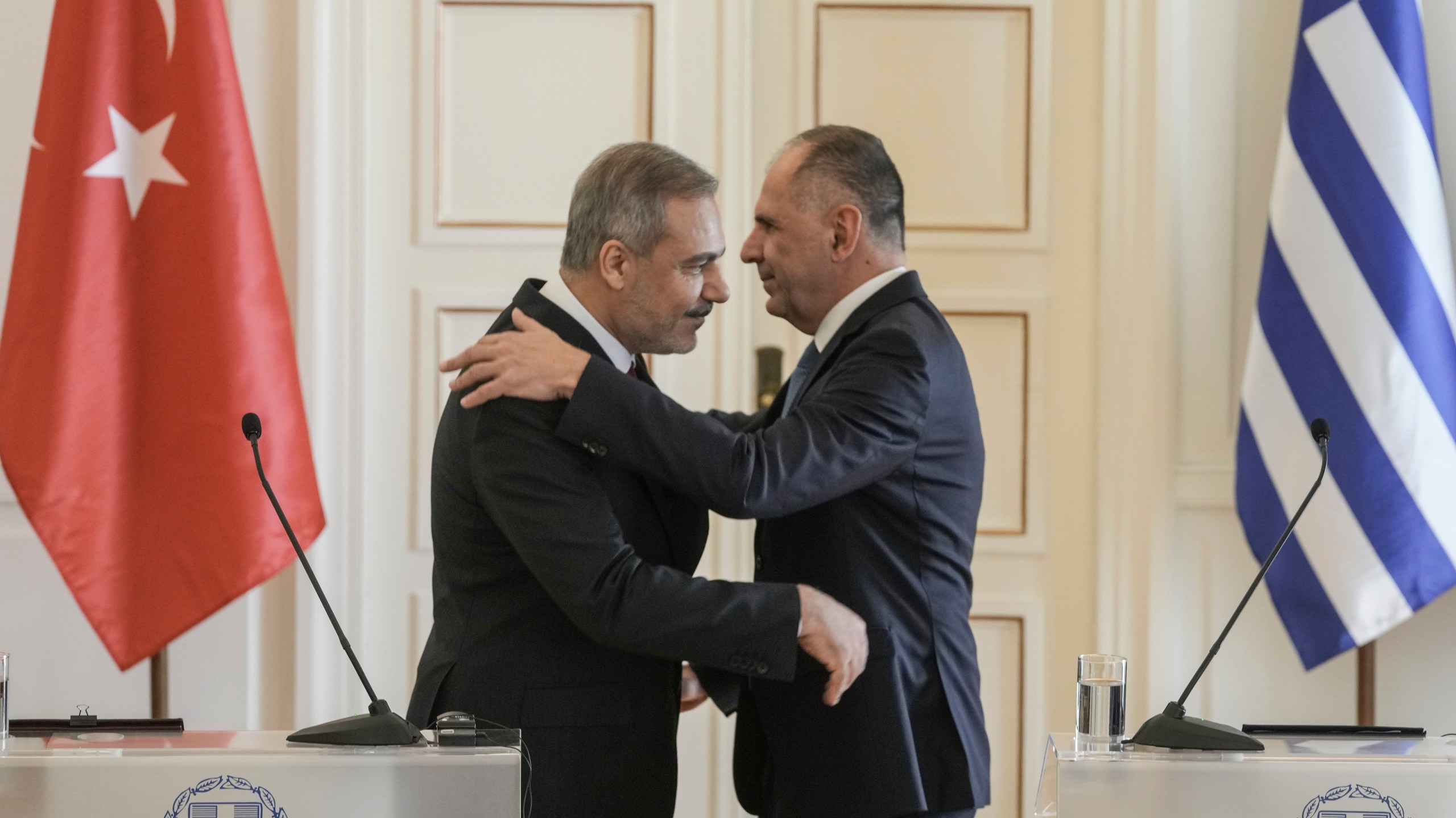 Greek Foreign Minister George Gerapetritis, right and his Turkish counterpart Hakan Fidan hug at the end of a join news conference, in Athens, Greece, Friday, Nov. 8, 2024. (AP Photo/Thanassis Stavrakis)