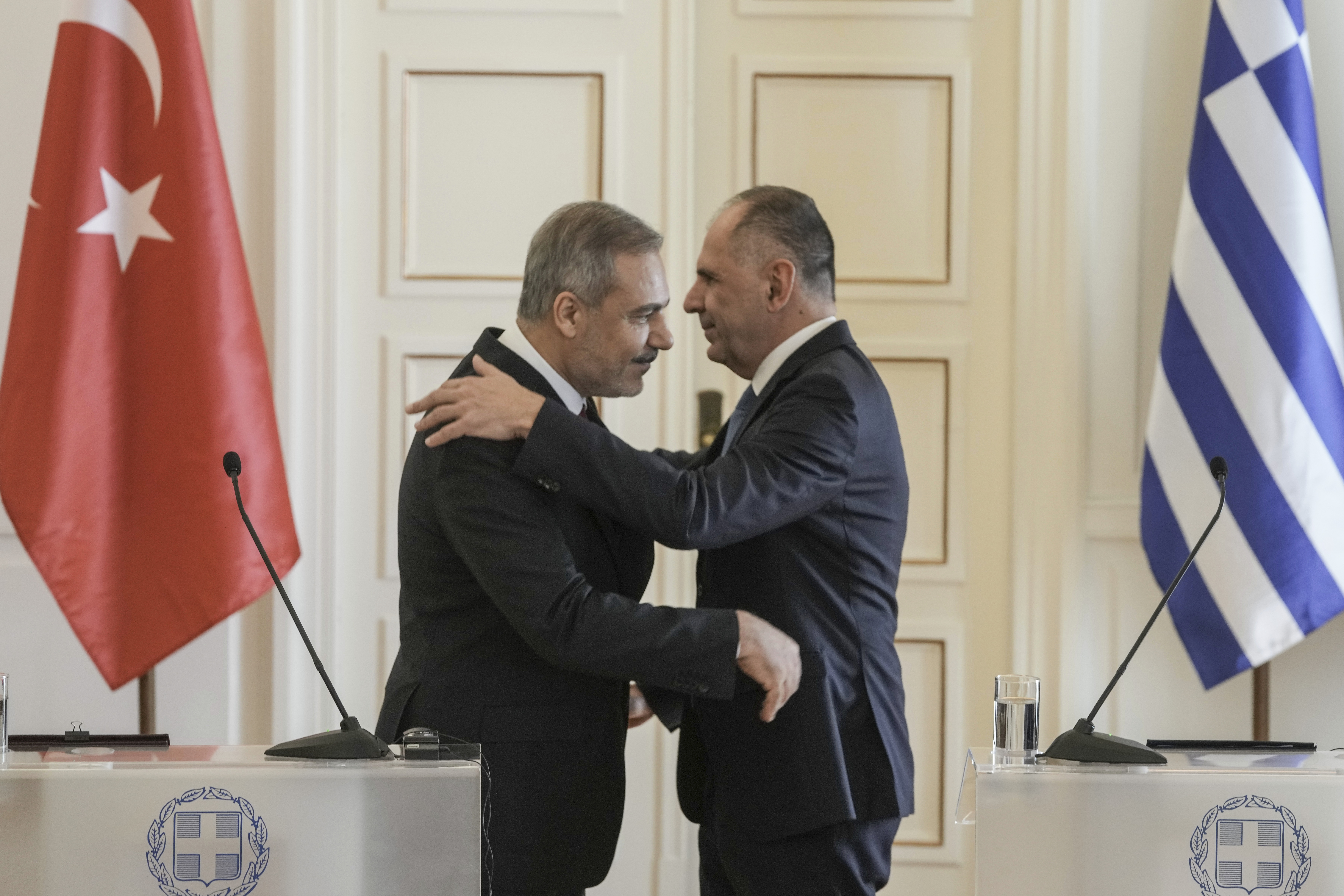 Greek Foreign Minister George Gerapetritis, right and his Turkish counterpart Hakan Fidan hug at the end of a join news conference, in Athens, Greece, Friday, Nov. 8, 2024. (AP Photo/Thanassis Stavrakis)