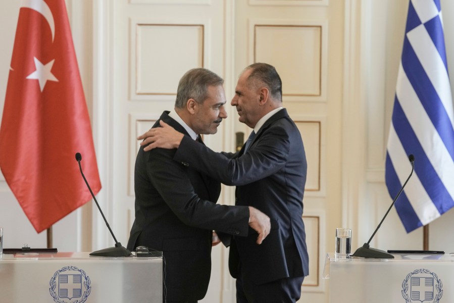 Greek Foreign Minister George Gerapetritis, right and his Turkish counterpart Hakan Fidan hug at the end of a join news conference, in Athens, Greece, Friday, Nov. 8, 2024. (AP Photo/Thanassis Stavrakis)