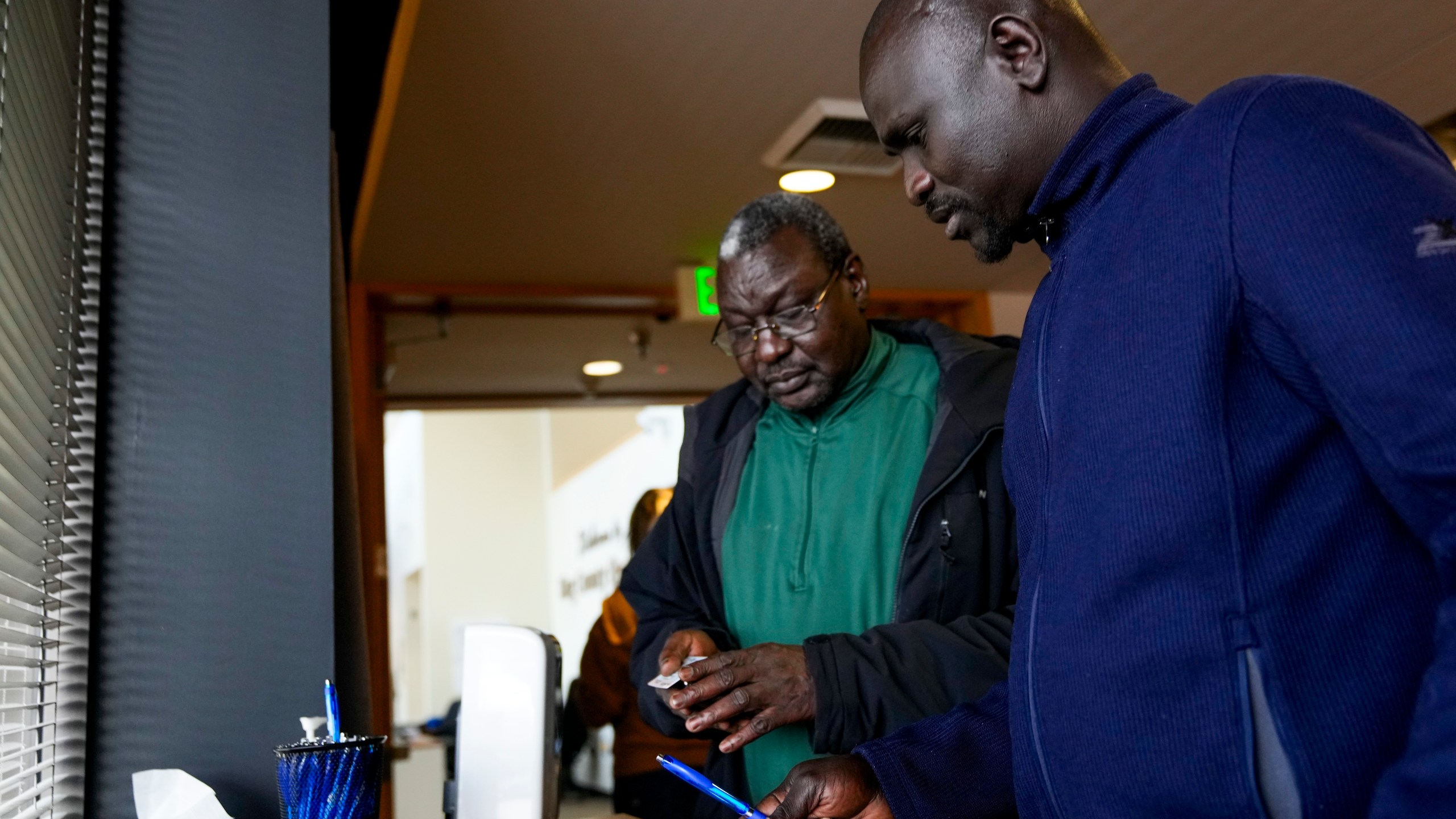 FILE - Michael Mayen, right, originally from South Sudan, registers to vote for the first time with cousin Awoul Ayom, left, at the King County Elections headquarters on Election Day, Tuesday, Nov. 5, 2024, in Renton, Wash. (AP Photo/Lindsey Wasson, File)