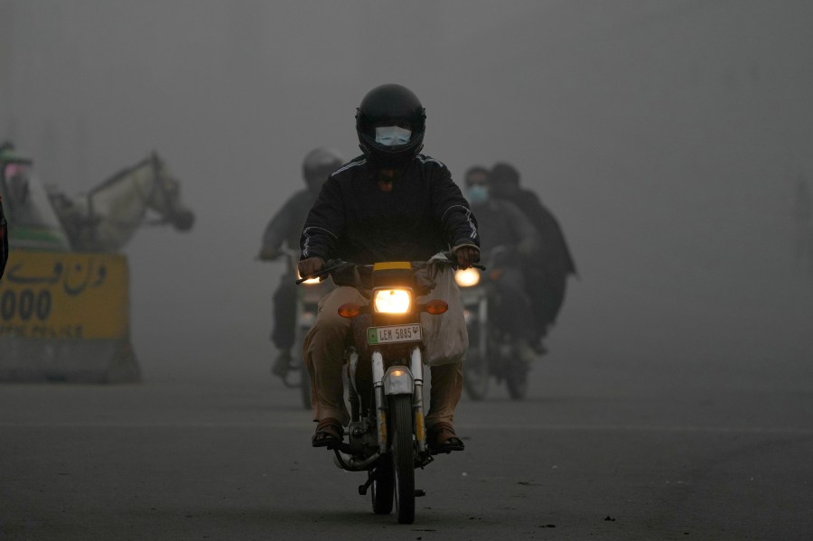 Motorcyclists move with headlights in the morning due to smog in Lahore, Pakistan, Friday, Nov. 8, 2024. (AP Photo/K.M. Chaudary)