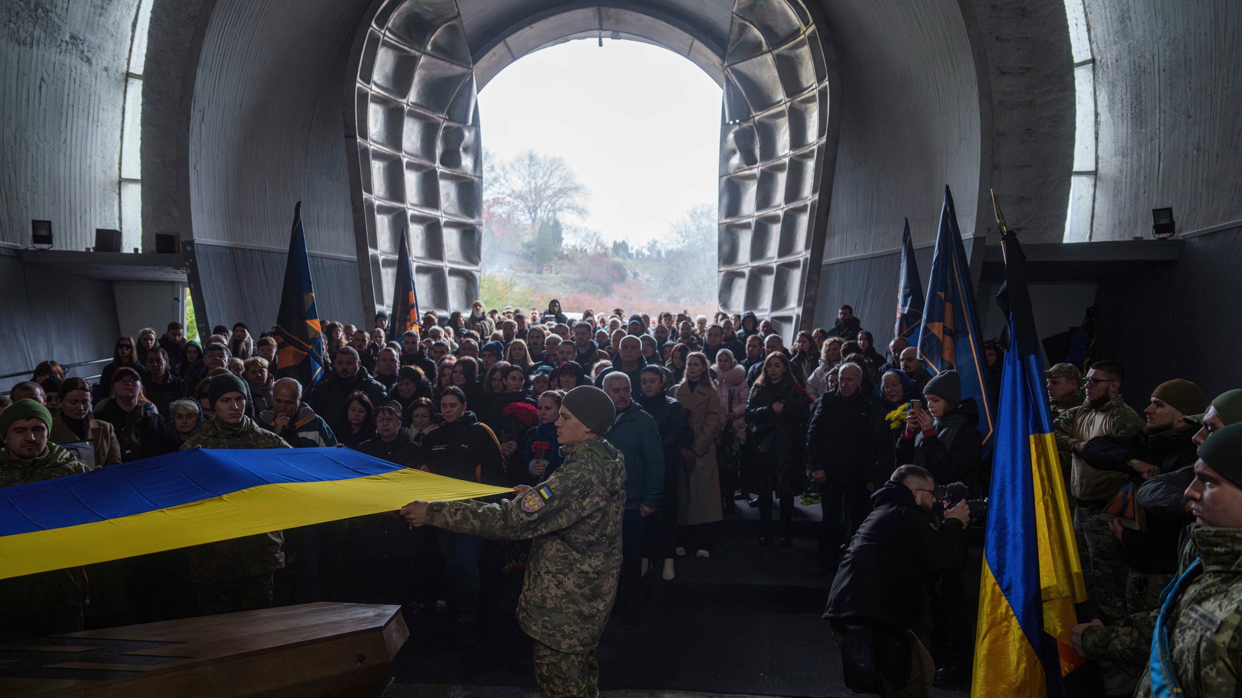 Honour Guard hold the national flag above the coffin of fallen Ukrainian serviceman of 3rd assault brigade Danylo Liashkevych, known as "Berserk", who was killed together with his girlfriend Valentyna Nagorna, known as "Valkiria", during the funeral ceremony at a crematorium in Kyiv, Ukraine, Friday Nov. 8, 2024. (AP Photo/Evgeniy Maloletka)