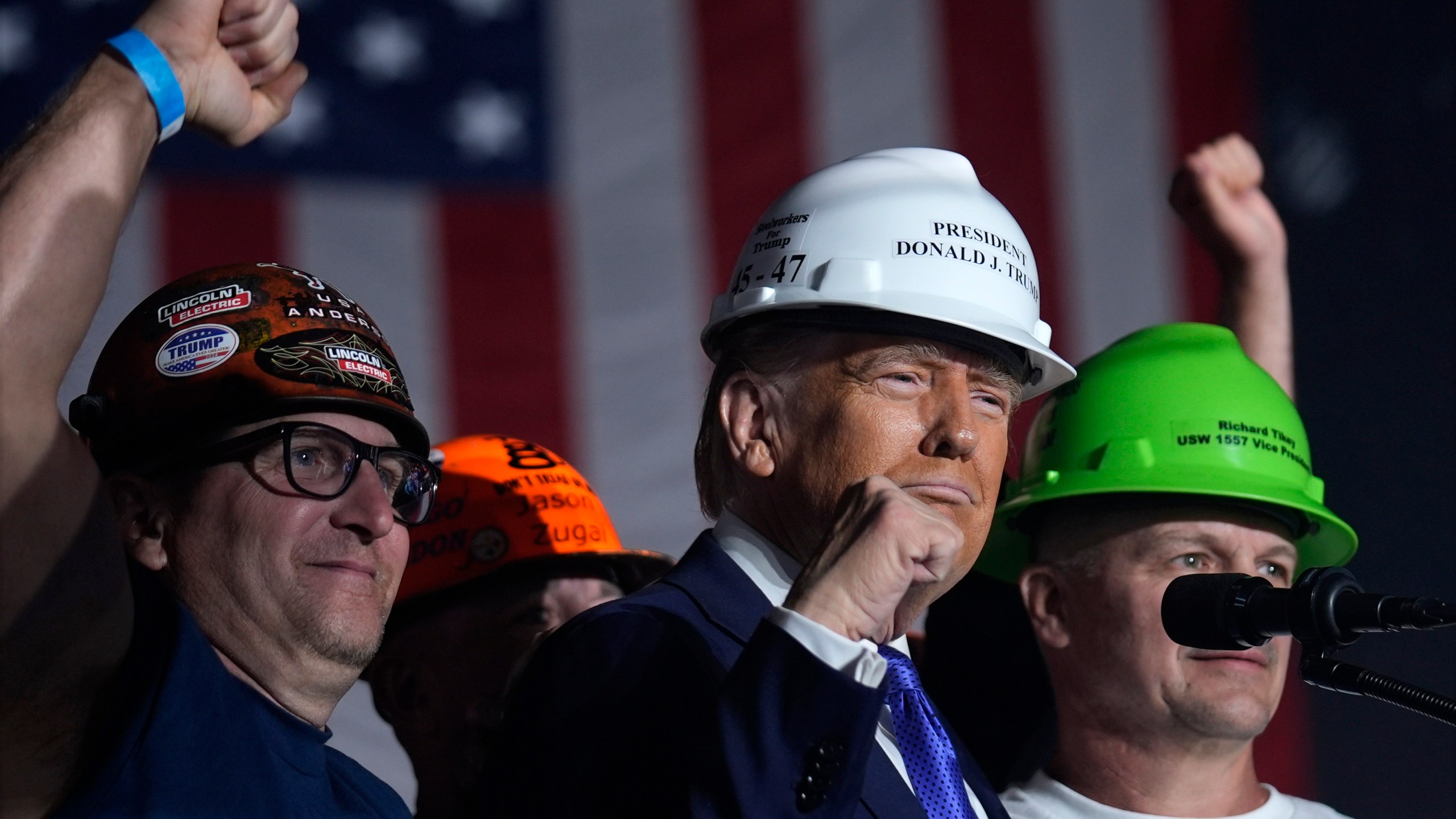 Republican presidential nominee former President Donald Trump stands on stage with steelworkers as he speaks during a campaign rally at Arnold Palmer Regional Airport, Saturday, Oct. 19, 2024, in Latrobe, Pa. (AP Photo/Evan Vucci)