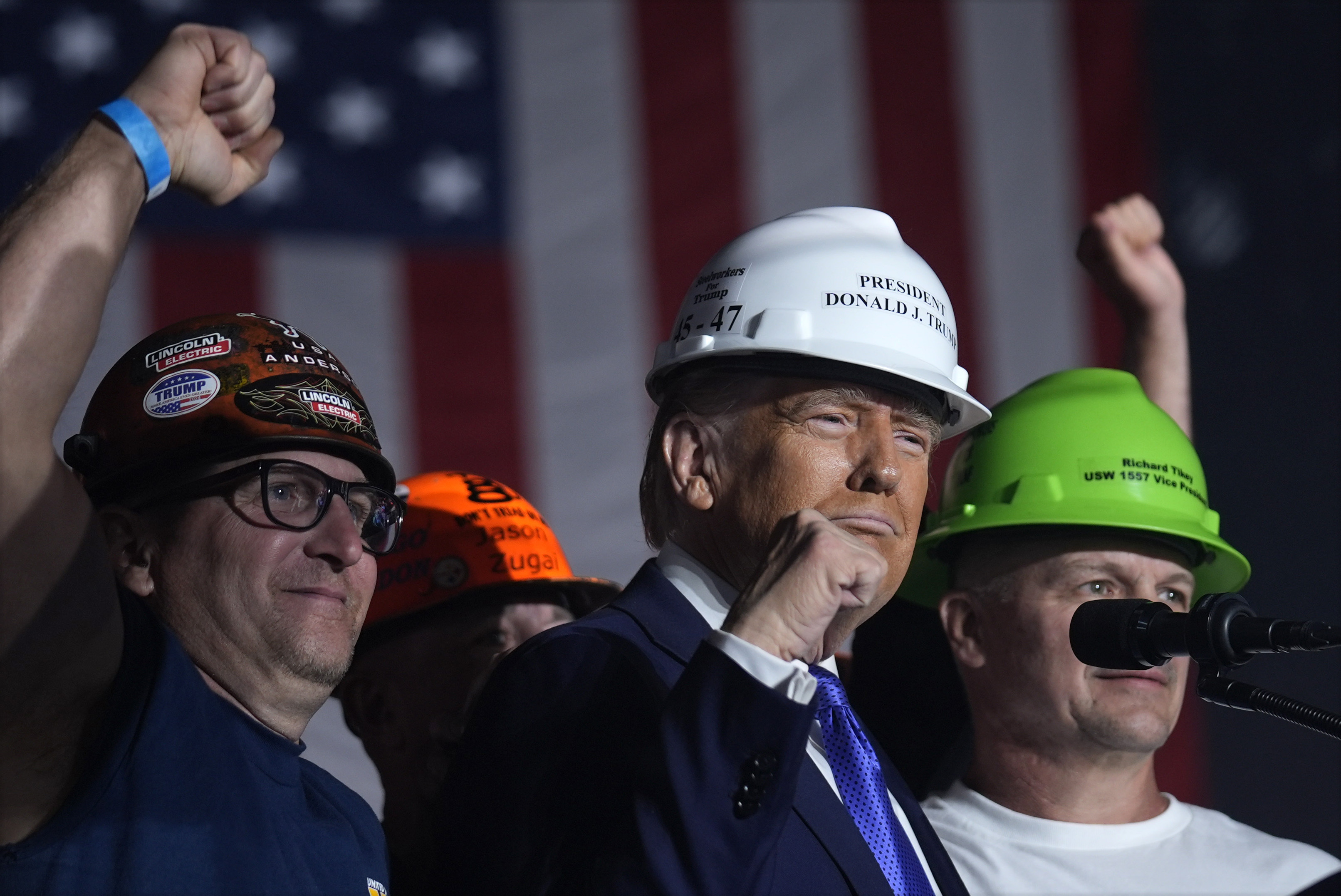 Republican presidential nominee former President Donald Trump stands on stage with steelworkers as he speaks during a campaign rally at Arnold Palmer Regional Airport, Saturday, Oct. 19, 2024, in Latrobe, Pa. (AP Photo/Evan Vucci)