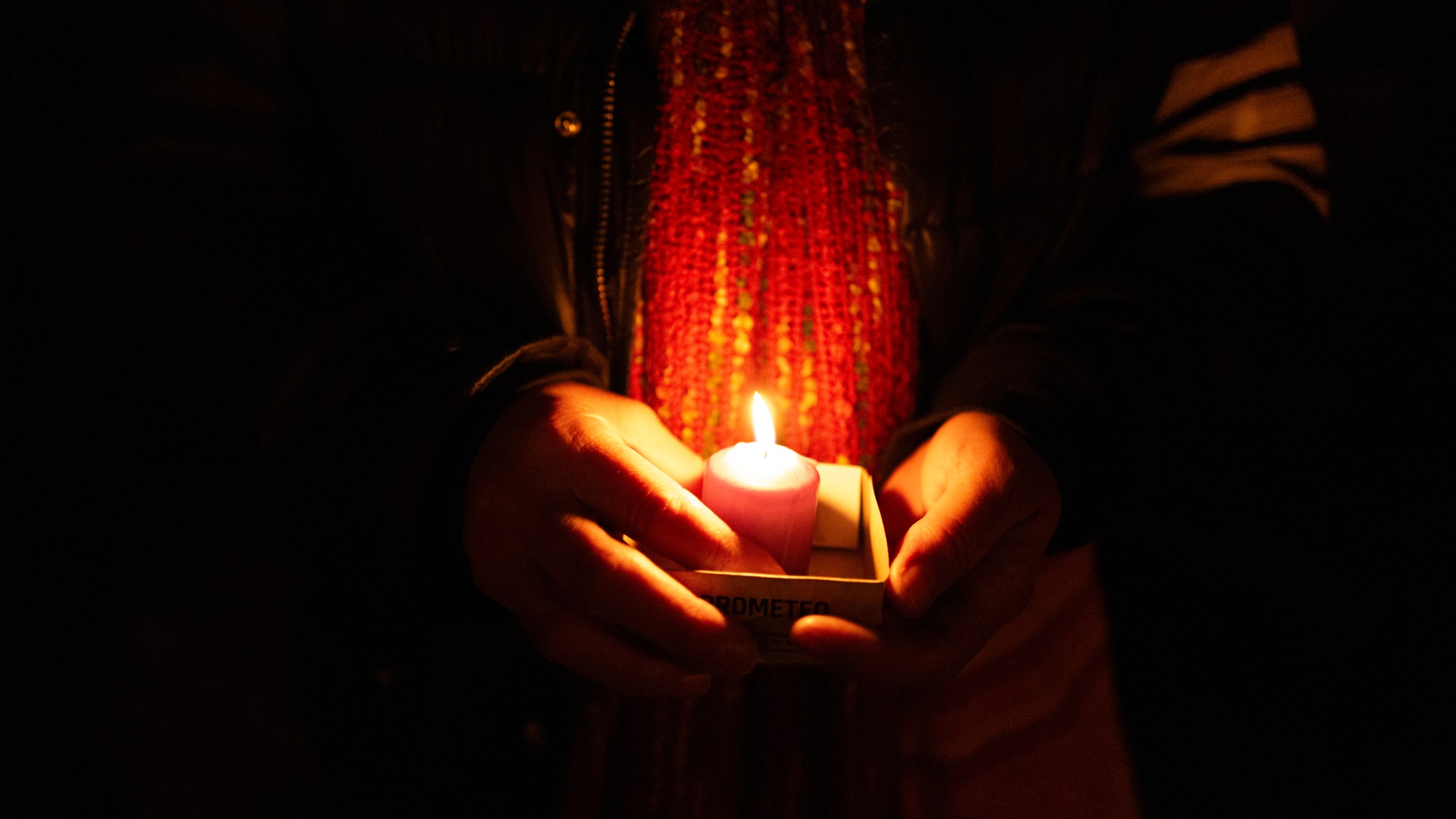 A friend holds a candle while remembering Mackenzie Michalski, an 31-year-old American tourist who was murdered while on vacation, during a candlelight vigil in Budapest, Hungary, Saturday, Nov. 9, 2024. (AP Photo/Bela Szandelszky)