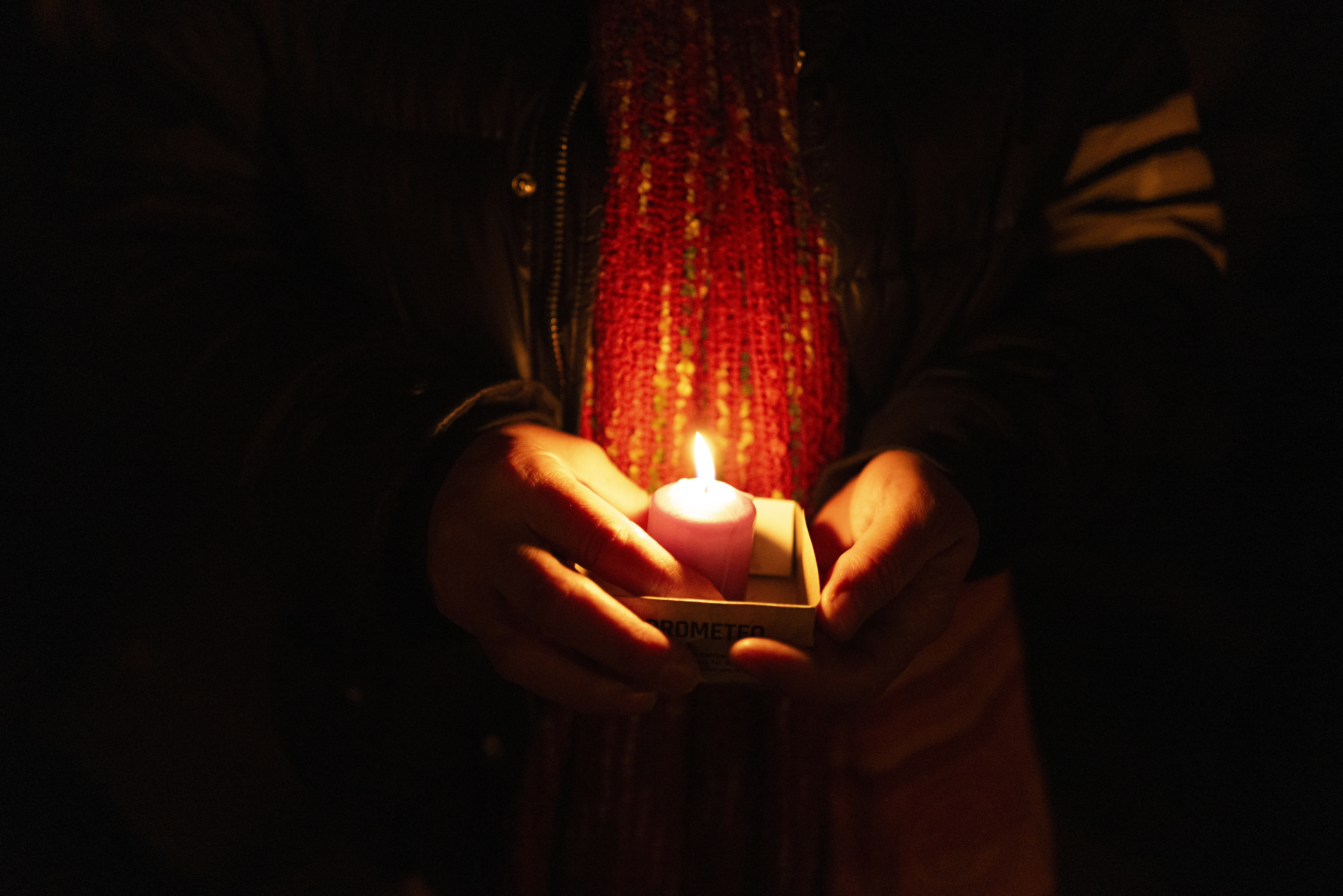 A friend holds a candle while remembering Mackenzie Michalski, an 31-year-old American tourist who was murdered while on vacation, during a candlelight vigil in Budapest, Hungary, Saturday, Nov. 9, 2024. (AP Photo/Bela Szandelszky)