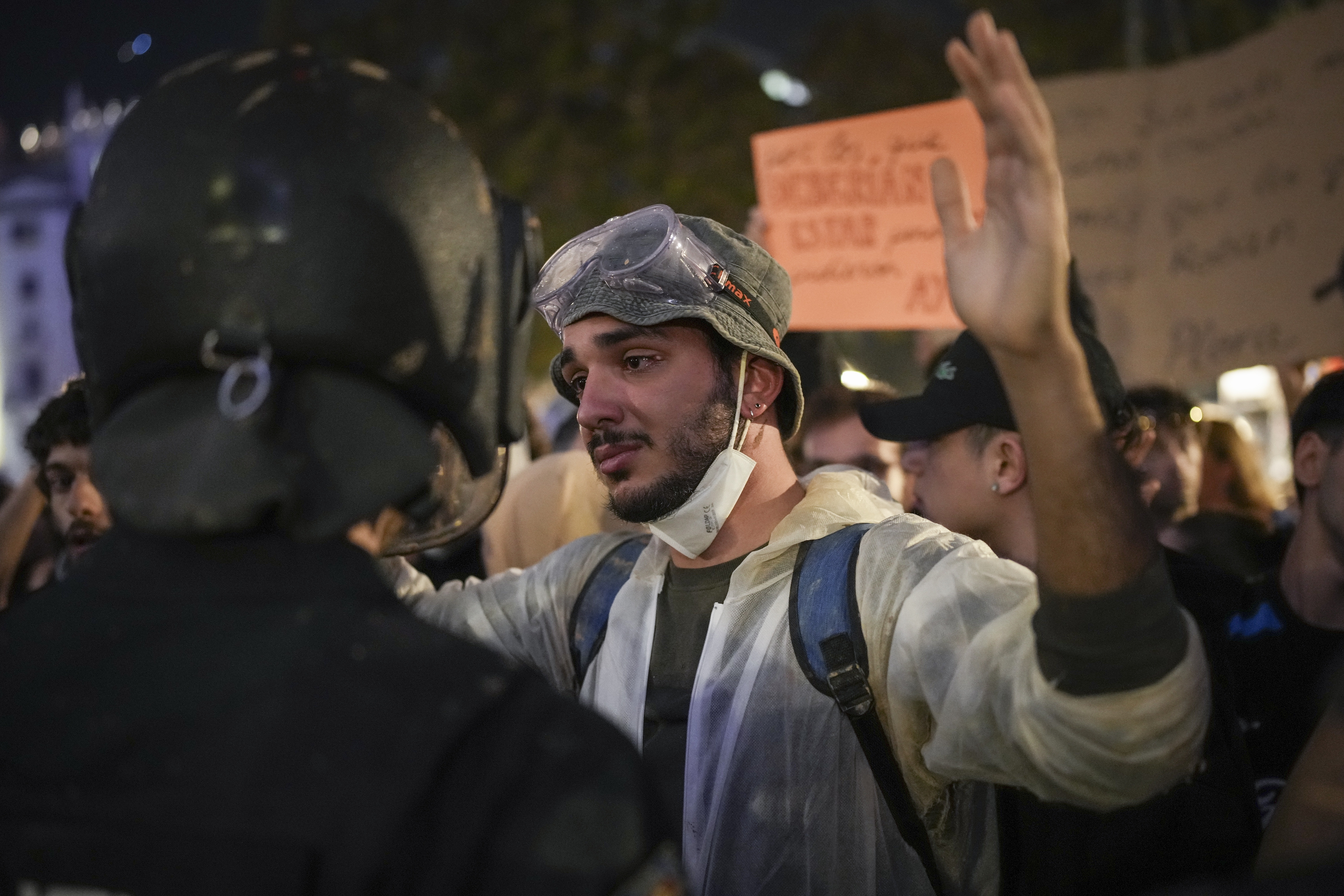 A demonstrator holds his hands up in front of riot police during a protest organized by social and civic groups, denouncing the handling of recent flooding under the slogan "Mazón, Resign," aimed at the president of the regional government Carlos Mazon, in Valencia, Spain, Saturday, Nov. 9, 2024. (AP Photo/Emilio Morenatti)