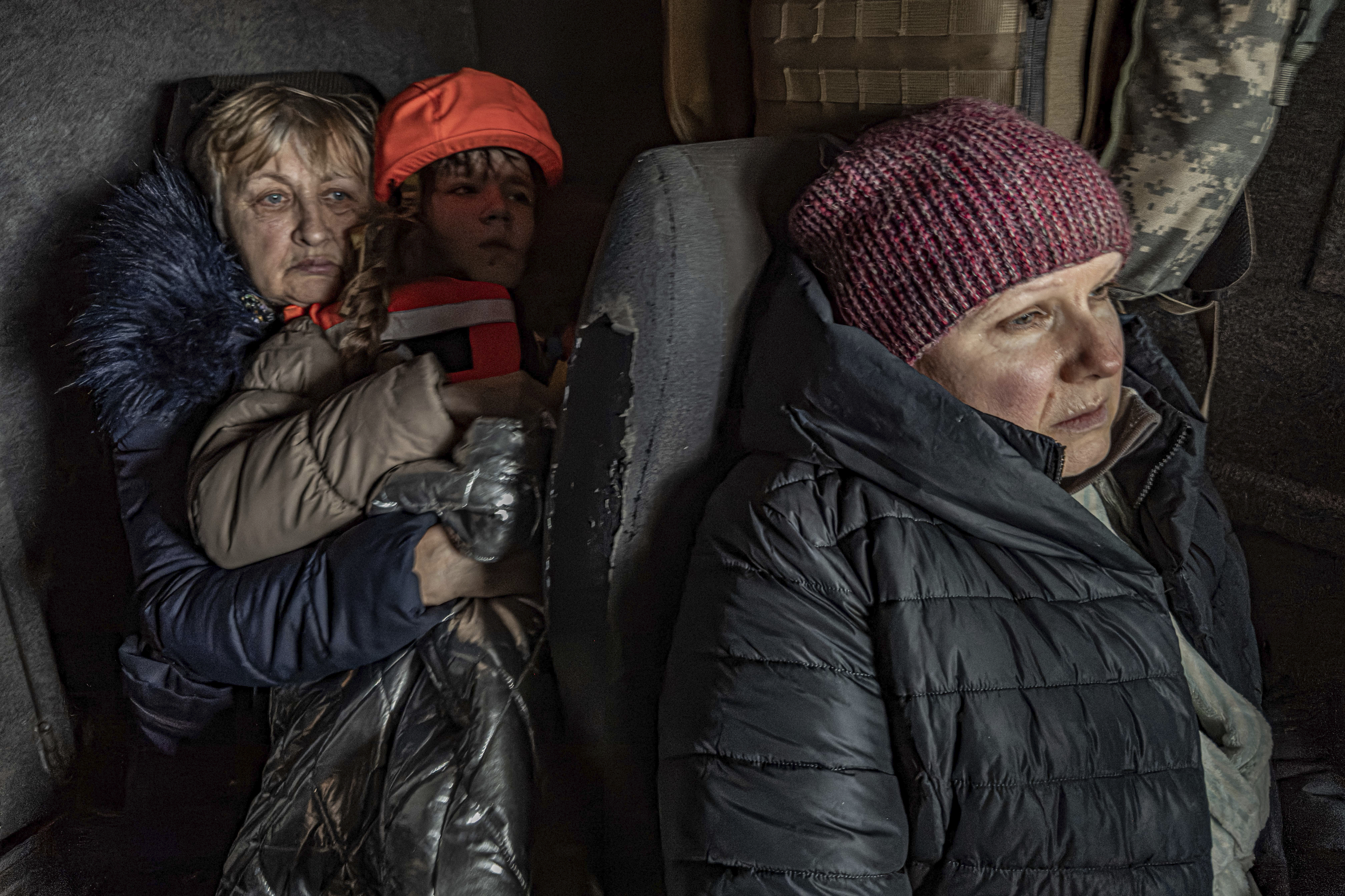 Katia, 11, with her grandmother and mother sit in an armoured minivan during en evacuation by the "White Angels" police unit in Kurakhove, Donetsk region, Ukraine, on Nov. 4, 2024. (AP Photo/Anton Shtuka)