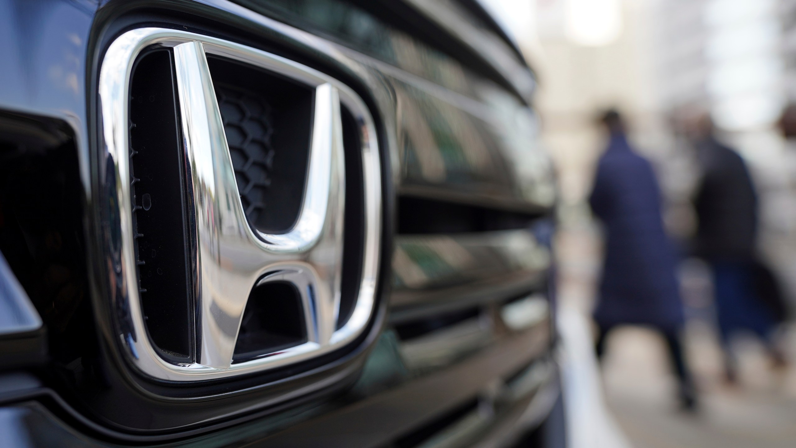 FILE - People walk near the logo of Honda Motor Company at a showroom on Feb. 8, 2022, in Tokyo. (AP Photo/Eugene Hoshiko, File)