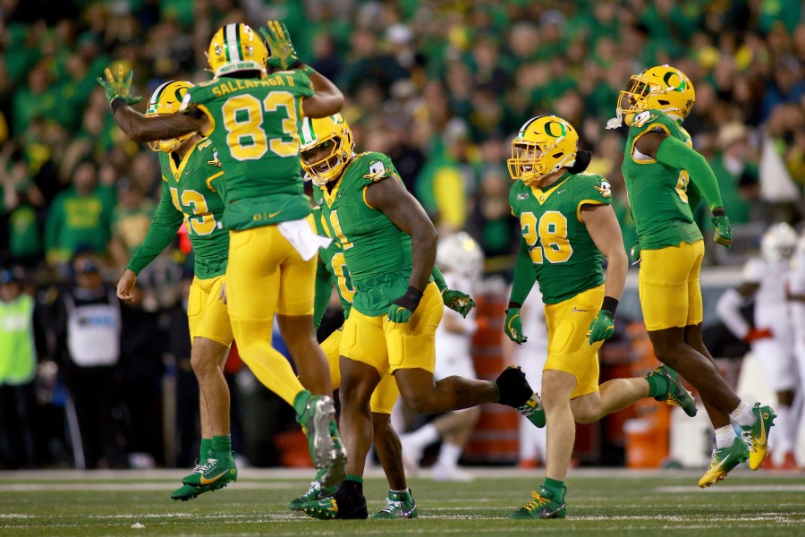 Oregon offensive lineman Gernorris Wilson (91) is congratulated by teammates after a touchdown during an NCAA college football game against Maryland, Saturday, Nov. 9, 2024, in Eugene, Ore. (AP Photo/Lydia Ely)